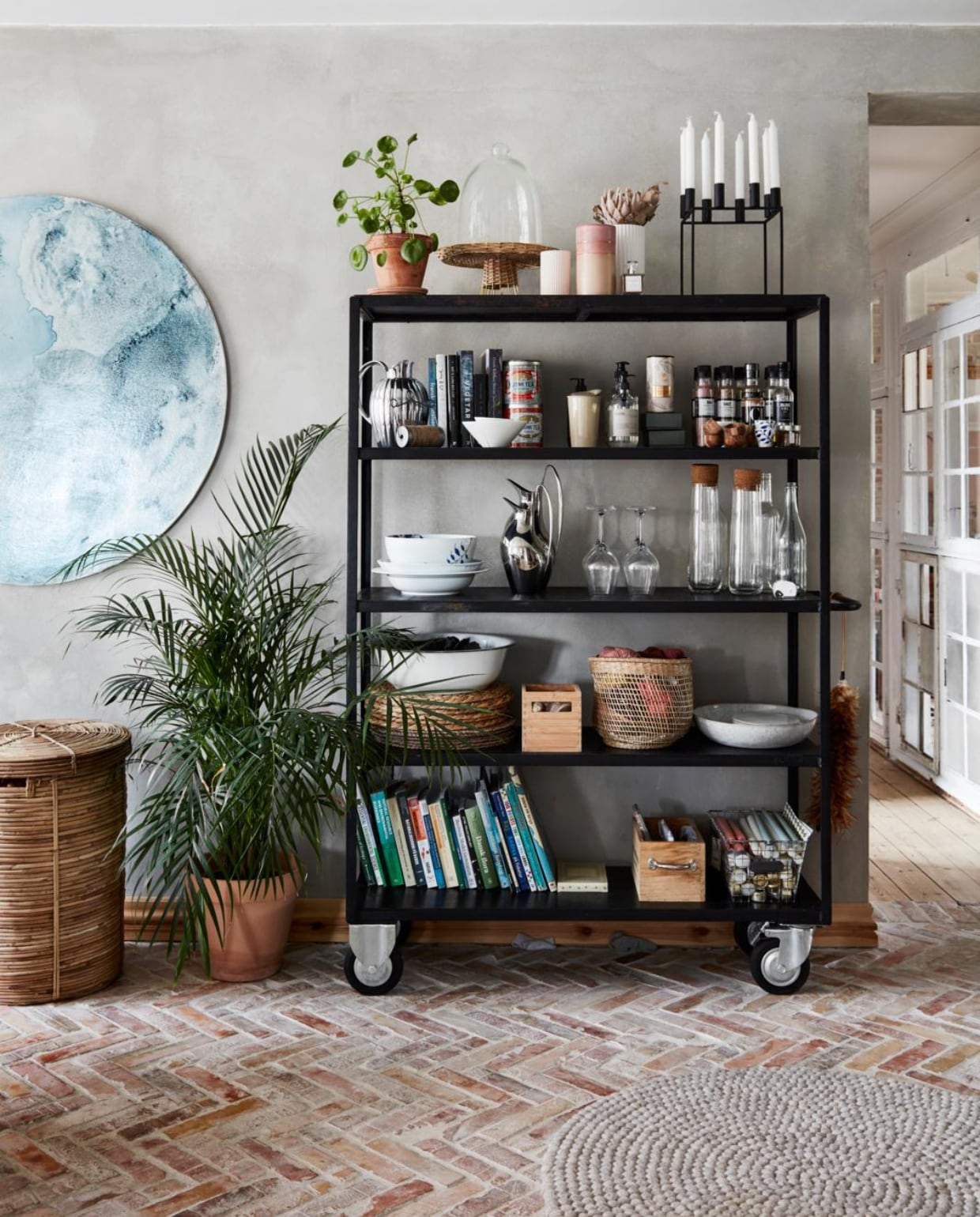 Rolwagen, bamboe wasmand House Doctor. Kandelaar By Lassen. Vazen en lijsten Royal Copenhagen. Metalen kannen Georg Jensen. Glaswerk Holmegaard. Rond kunstwerk Patricia Brøndum. Overig herkomst onbekend. vtwonen 12-2021 | productie Living Stories | styling Pia Olsen | fotografie Stine Christiansen