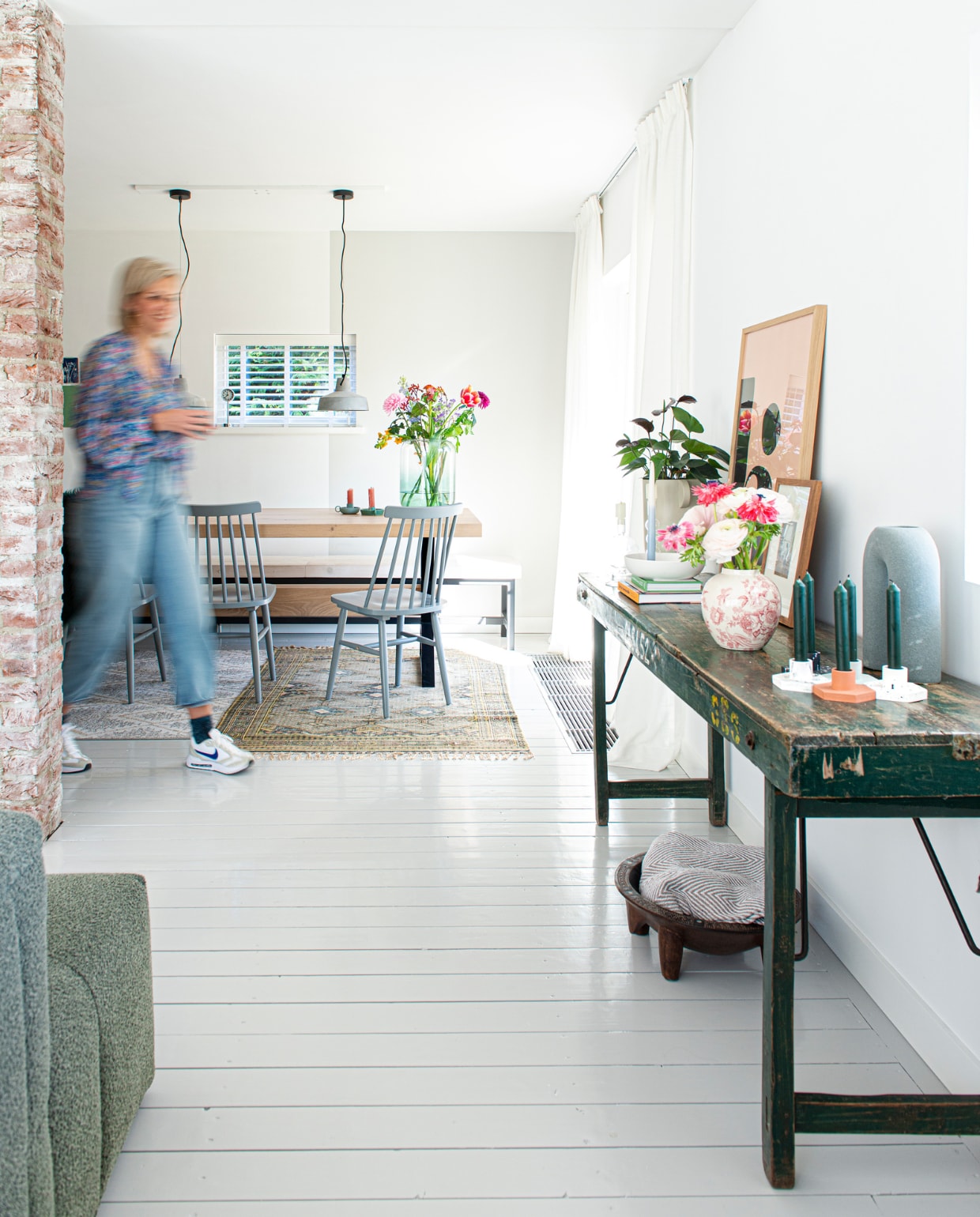 Massief eiken tafel met stalen frame PMP Furniture, stoelen Tressia van Kave Home, op maat gemaakte eettafelbank van wit gebeitste vurenhouten balken en een metalen frame Jorg steigerhout. Betonnen hanglampen Karwei, grote vaas met kleurverloop Kwantum, groene kaarsenstandaards Hema, stonewashed karpet HKliving. Overig zie vorige pagina's. vtwonen special DIY 6-2022 | productie De Binnenkijkers | styling Jeske Weel | fotografie Caroline Coehorst