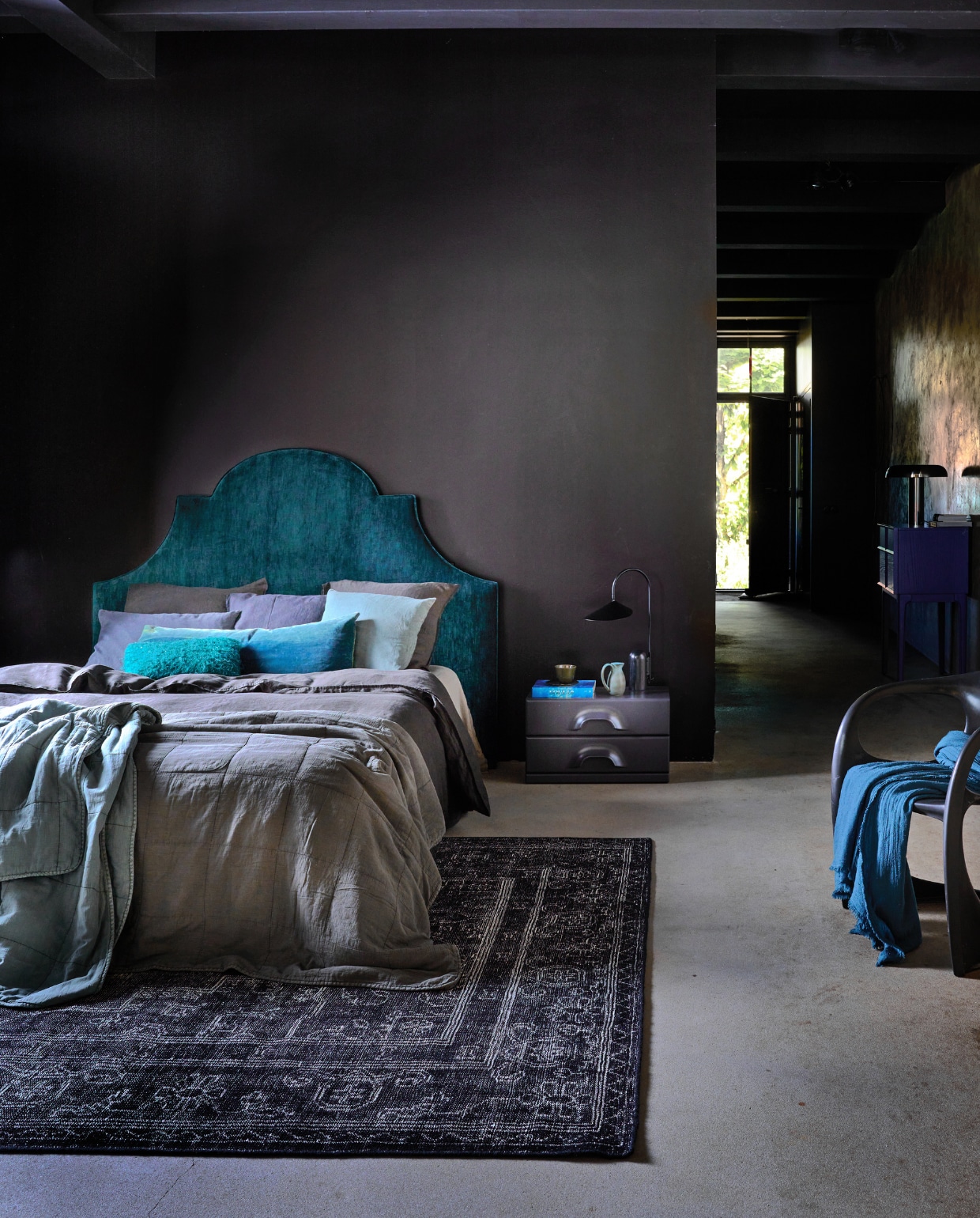 Op maat gemaakt hoofdbord, prijs op aanvraag (stoffeershop.nl), bekleed met stof Orion Jade K5058/24, 140 cm breed, per meter € 85,- (kirkbydesign.com). Muurverf Lab Paint Black Clay 40, prijs op aanvraag (Vestingh). Grijs linnen dekbedovertrek, 220x240 cm € 89,99, kussenslopen, 60x60 cm, set van 2 € 49,99 (zarahome.com). Grijze en petrolkleurige sprei, vanaf € 79,95, grijs en turkoois katoenen kussen, 50x50 cm € 24,95, grijs katoenen kussen, 50x70 cm € 36,80 (iblaursen.nl). Ladekast Chest van HKliving in Charcoal, 60x35x35,2 cm (bxdxh) € 476,-, handgeknoopt vloerkleed van HKliving, wol en katoen, 300x200 cm € 1525,99, leeslamp Arum van Ferm Living, aluminium en marmer € 429,-, chromen tafellamp Mushroom van HKliving € 215,99 (vtwonen.nl/shop). Dressoir June, 80x45x100 cm (bxdxh) € 980,- (zuiver.nl). Petrolkleurige kan € 30,30, donkergroene beker € 9,90 (nordal.eu). Vintage eetkamerstoel van Alexander Begge voor Casala € 300,-(Instagram @iconic_objects). Chromen vaas Cones S € 34,50 (zuiver.nl). Overig privébezit. vtwonen 12-2023 | styling Cleo Scheulderman | fotografie Jeroen van der Spek
