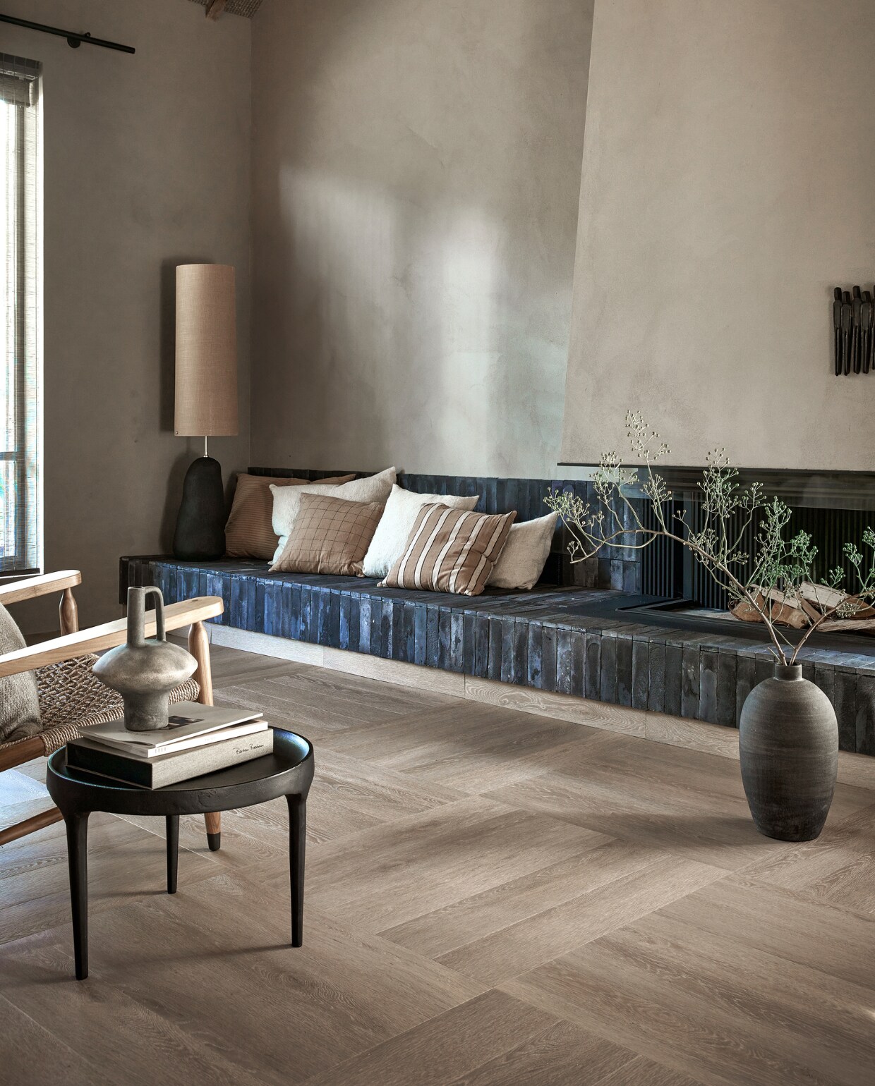 Pvc-vloer Herringbone in Warm Natural, dryback, 76,5x15,3 cm, per m² € 44,95, ook verkrijgbaar als click, per m² € 57,95.M.m.v. vtwonen.nl/shop (kussens van Ferm Living, donkergrijze lampenvoet Hebe van Ferm Living, lampenkap Eclipse van Ferm Living in Curry), 101cph.com (aluminium bijzettafel Phantom). Overig privébezit. vtwonen 12-2023 | productie Tanja Saarberg | styling Kim van Rossenberg | fotografie Peggy Janssen