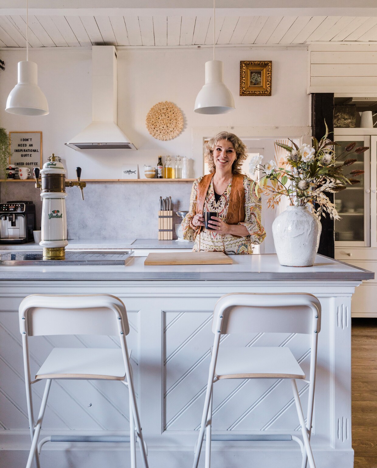 Keukenkasten, betonlook werkblad, apparatuur, barkrukken, lampen, messenblok, glazen flessen, pepermolen, snijplank en vitrinekast Ikea. Bar en antieke Grolschtap stonden al in het huis, geschilderd in Ral 9016. Koffiemachine Philips. Vaas en zijden bloemen MK Objecten. Messen Berghoff, letterbord Karwei, tegel met vis Huushinne, kommen HKliving, koffiekoppen Douwe Egberts, onderzetter aan wand Kwantum, schilderij erfstuk. Emaillen kan Dille &amp; Kamille, muurverf Ral 9016, vloer Quick-Step. Overig onbekend. vtwonen 12-2023 | styling Anouschka Witteveen | fotografie Corine Hoge Bavel