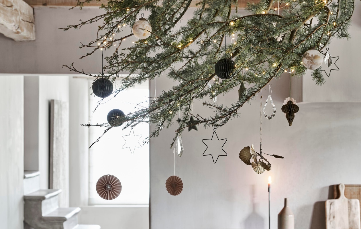 Papieren waaiers, honeycombballen, gemarmerde ballen  (intratuin.nl). Ginko hanger, sterren, glazen pegels vanaf (weldaad.com). Groene wijnglazen van Nordal, wafeldoek van Bungalow, fles van Madam Stoltz (deens.nl). Kandelaar (stoermetaal.nl). Overig privébezit. vtwonen feestbijlage 12-2020 | styling Marlies Does | fotografie Bart Brussee