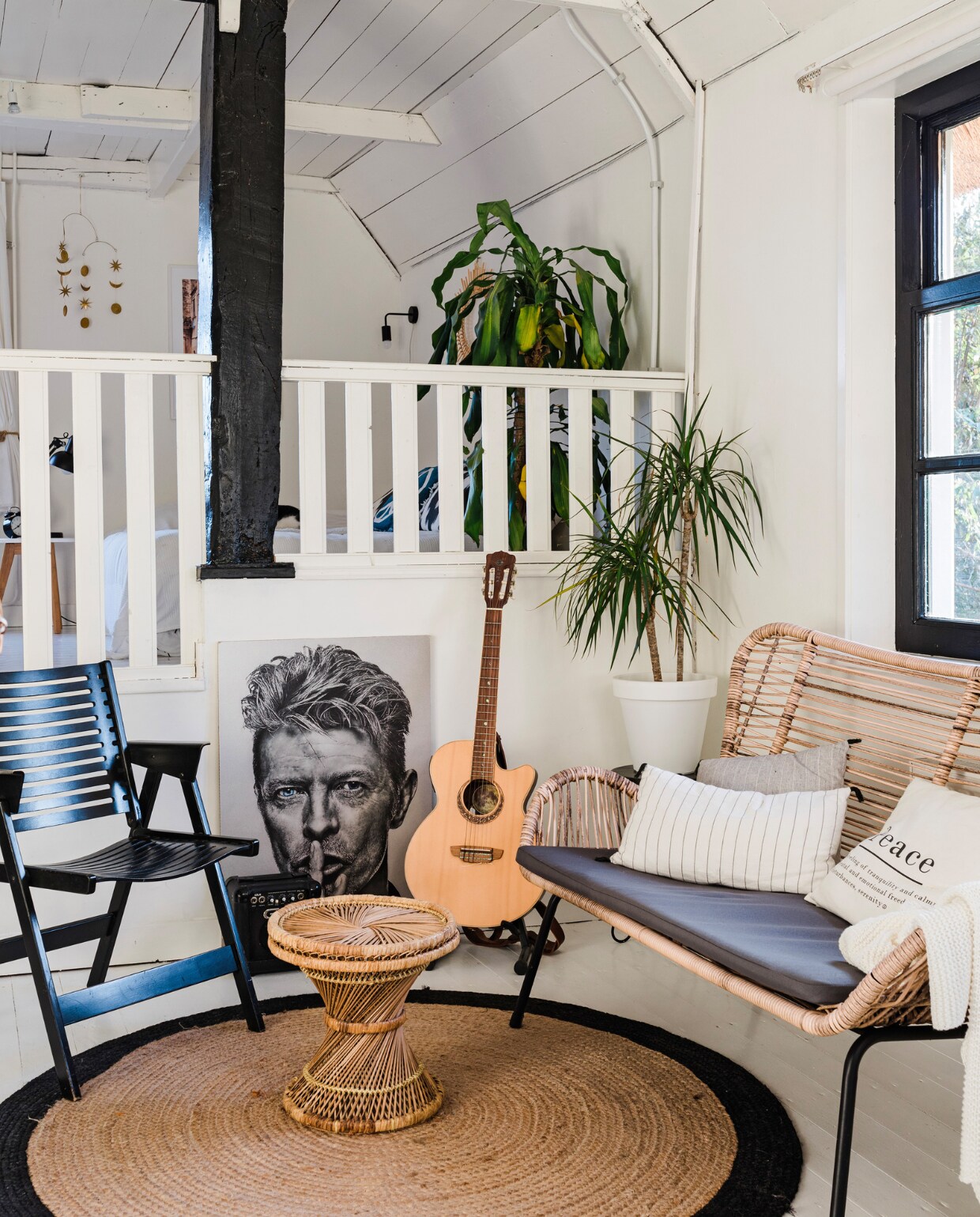 Stoel Rex van Niko Kralj en bijzettafel Marktplaats. Vloerkleed LaForma, bank Leen Bakker, gestreepte kussens Maisons du Monde, kussen Peace H&amp;M Home, plaid Ikea gitaar Van der Glas, mobile Silent Night van Anna + Nina. Plant en pot Intratuin. Verf muren en plafond Ral 9010. Verf gebint en ramen zijdeglans zwart, vloerverf wit van Histor. Overig onbekend. vtwonen 12-2023 | styling Anouschka Witteveen | fotografie Corine Hoge Bavel