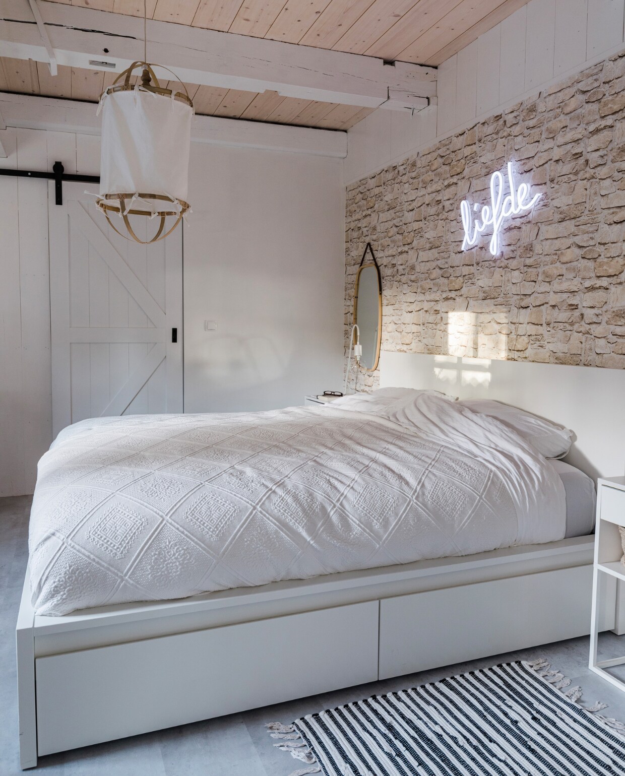 Bed en nachtkastje Ikea. Vloerkleed Trendcarpet, hanglamp Stijlz Concept, spiegel Present Time, tafellamp vtwonen, behang Bauhaus, neonlamp Liefde van Qazqa, schuifdeur Weekamp Deuren, schuifdeursysteem Barnwoodweb, vloer betonlook laminaat Praxis. vtwonen 12-2023 | styling Anouschka Witteveen | fotografie Corine Hoge Bavel