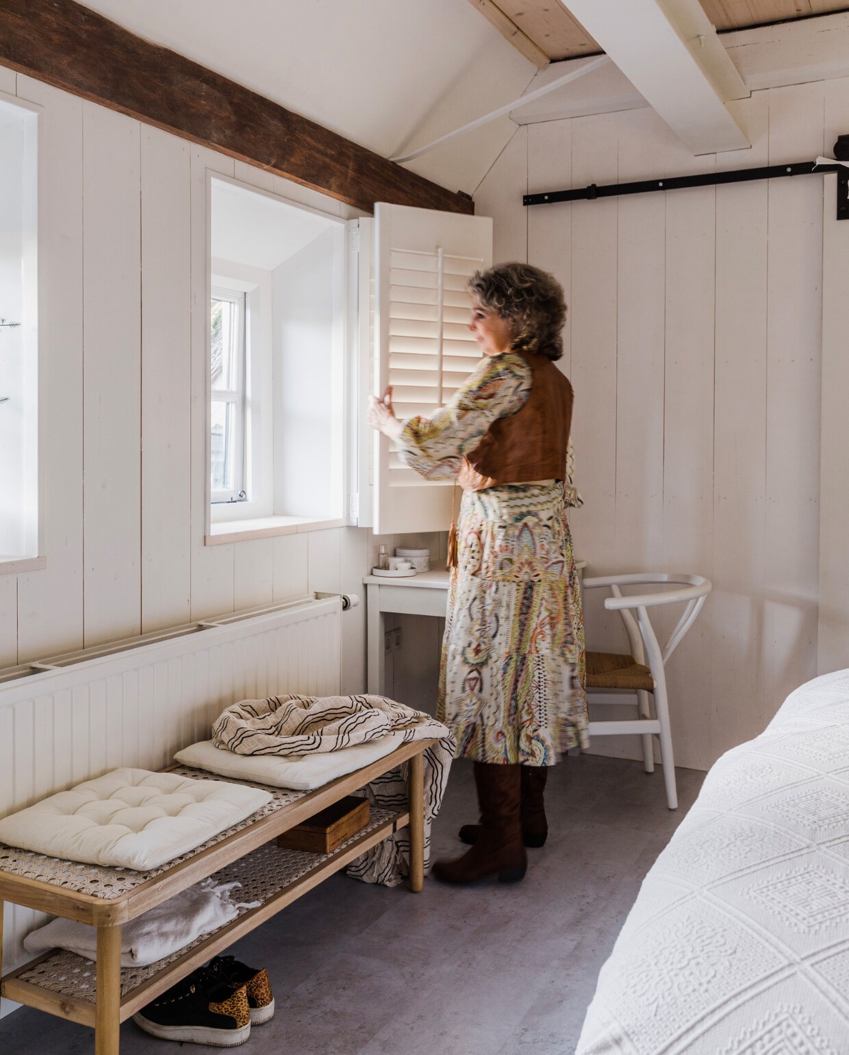 Schuifdeur Weekamp Deuren, schuifdeursysteem Barnwoodweb, tuinbank Karwei, kussens H&amp;M Home, plaid Lovi van Wehkamp, tafel erfstuk, stoel replica Wishbone Chair Marktplaats, vloer betonlook laminaat Praxis, shutters Marktplaats. Verf muren en houtwerk Ral 9016. Overig onbekend. vtwonen 12-2023 | styling Anouschka Witteveen | fotografie Corine Hoge Bavel