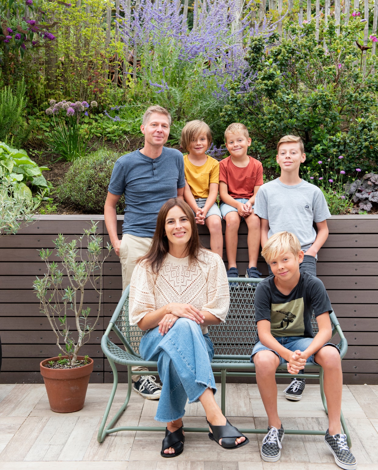 Mélanie, Kevin en hun kinderen in de tuin van hun  19e eeuwse boerderij in Ruette, België. vtwonen 3-2022 | productie De Binnenkijkers | styling Jeske Weel | fotografie Caroline Coehorst