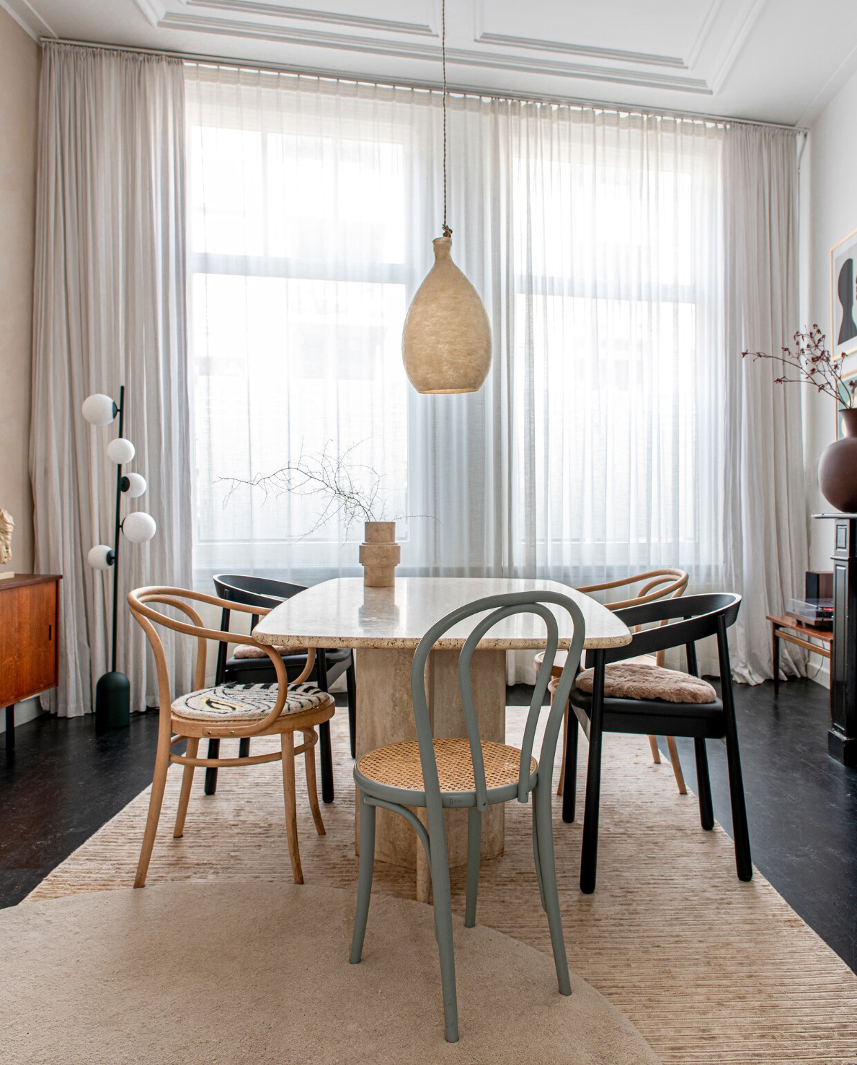 Eettafel Marktplaats. Zwarte stoelen en vloerlamp Kaktee van Fést. Andere stoelen en dressoir vintage. Gordijnen hingen er al, muurverf Kalkliter, soortgelijke hanglamp Vilt aan Zee, vloerkleden Ferm Living. Overig onbekend. vtwonen 12-2023 | productie De Binnenkijkers | styling  Jeske Weel | fotografie Caroline Coehorst