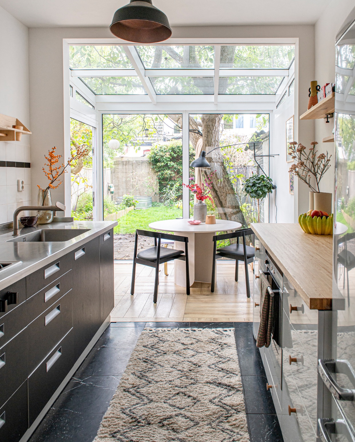 Keuken Arclinea, fruitschaal Catchii, vloerkleed HKliving, wandplank Hoeked. Tafel en stoelen Fést. Wandlamp Mantis BS2 by Dcw Éditions. Overig onbekend. vtwonen 12-2023 | productie De Binnenkijkers | styling Jeske Weel | fotografie Caroline Coehorst