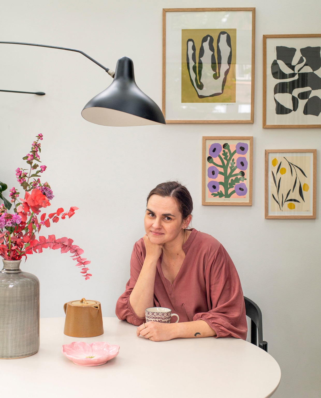 Prints van Poster Club, wandlamp Mantis BS2 van Dcw Éditions, stoel Fést. Overig onbekend. vtwonen 12-2023 | productie De Binnenkijkers | styling  Jeske Weel | fotografie Caroline Coehorst