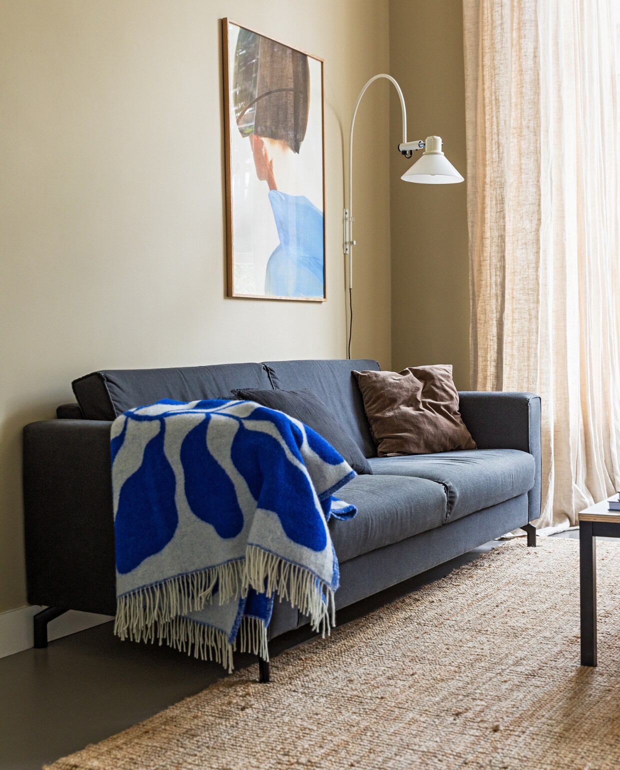 Muurkleur GN 080-08. Bank onbekend. Salontafel zelfgemaakt. Plaid van Linnea Andersson voor Arket. Wandlamp vintage. Vloerkleed Ikea. Print vanAmelie Hegardt. Linnen gordijnstof Jan Sikkes. vtwonen 10-2022 | styling Ilona Jongepier | fotografie Dana van Leeuwen