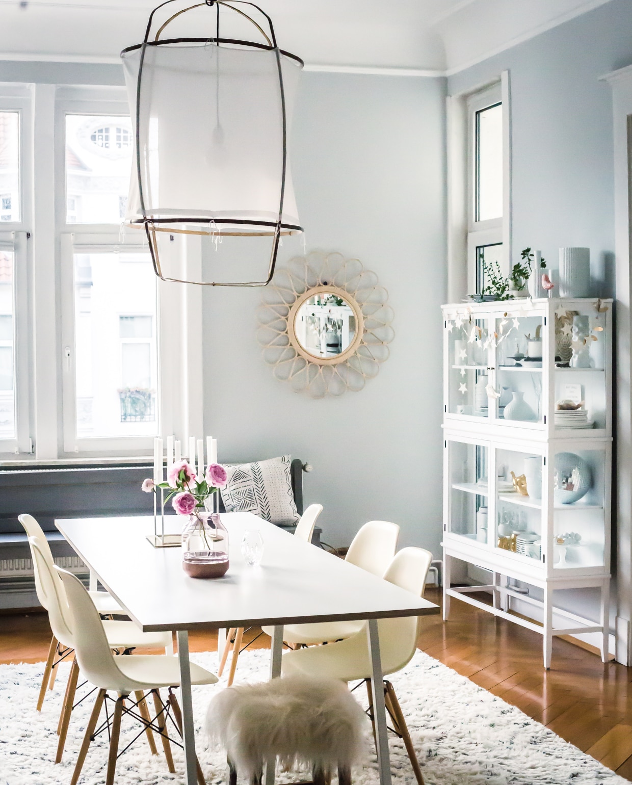 De spiegel is van westwing.nl, de servieskast van Oliver Furniture. Holly: ‘De kast is gevuld met servies van onder meer Marimekko, Lyngby en Rosenthal.’ Het vloerkleed is van Lulu &amp; Georgia, het grijze bankje van HK Living. De tafel kocht Holly bij Hay, de stoelen erbij zijn van Eames. Boven de tafel hangt lamp Z1 vanAy Illuminate. Op de muur zit kleur Dimpse no. 277 van Farrow &amp; Ball. vtwonen blogazine 09-2017 | styling &amp; fotografie Holly Becker