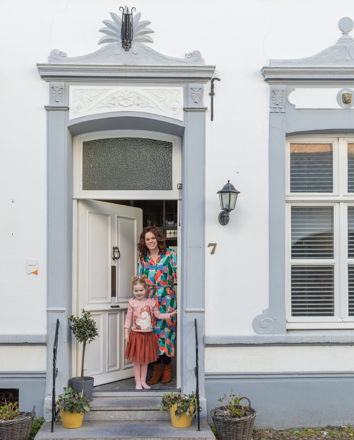 Marleen met Eef in de deuropenig van hun stadsvilla. vtwonen special binnenkijken 12-2023 | productie Cocofeatures | fotografie Anne den Haan