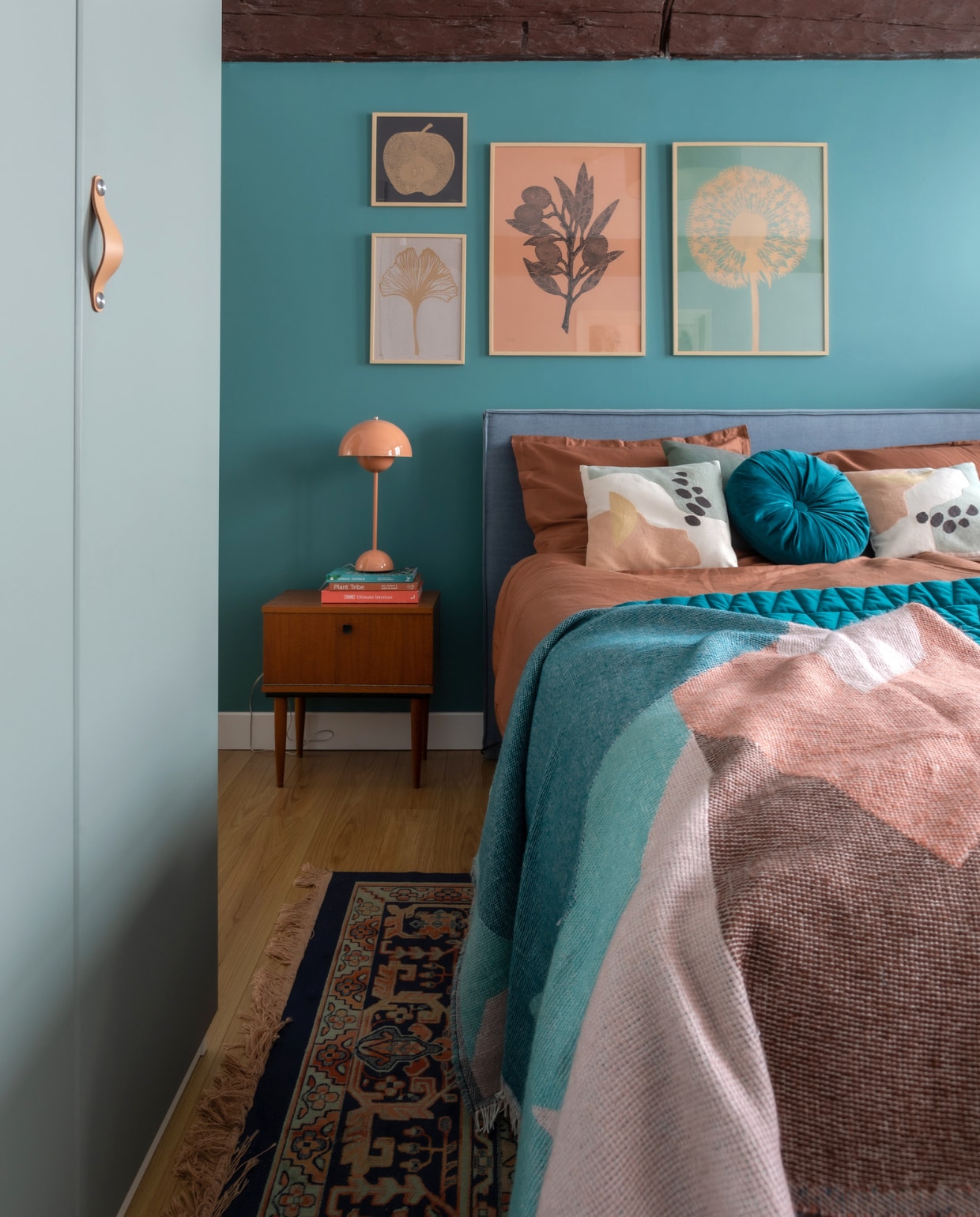 Bed Berden. Dekbedovertrek en rond kussen Kwantum, gekleurde kussens H&amp;M Home, blauw kussen Hay, blauwe sprei Made, gekleurde sprei Sissy-Boy. Vloerkleed Fonq. Nachtkast Marktplaats, tafellamp &amp;Tradition. Prints Monika Petersen, lijsten Bga. Overig onbekend. vtwonen special binnenkijken 12-2023 | productie Cocofeatures | fotografie Anne den Haan