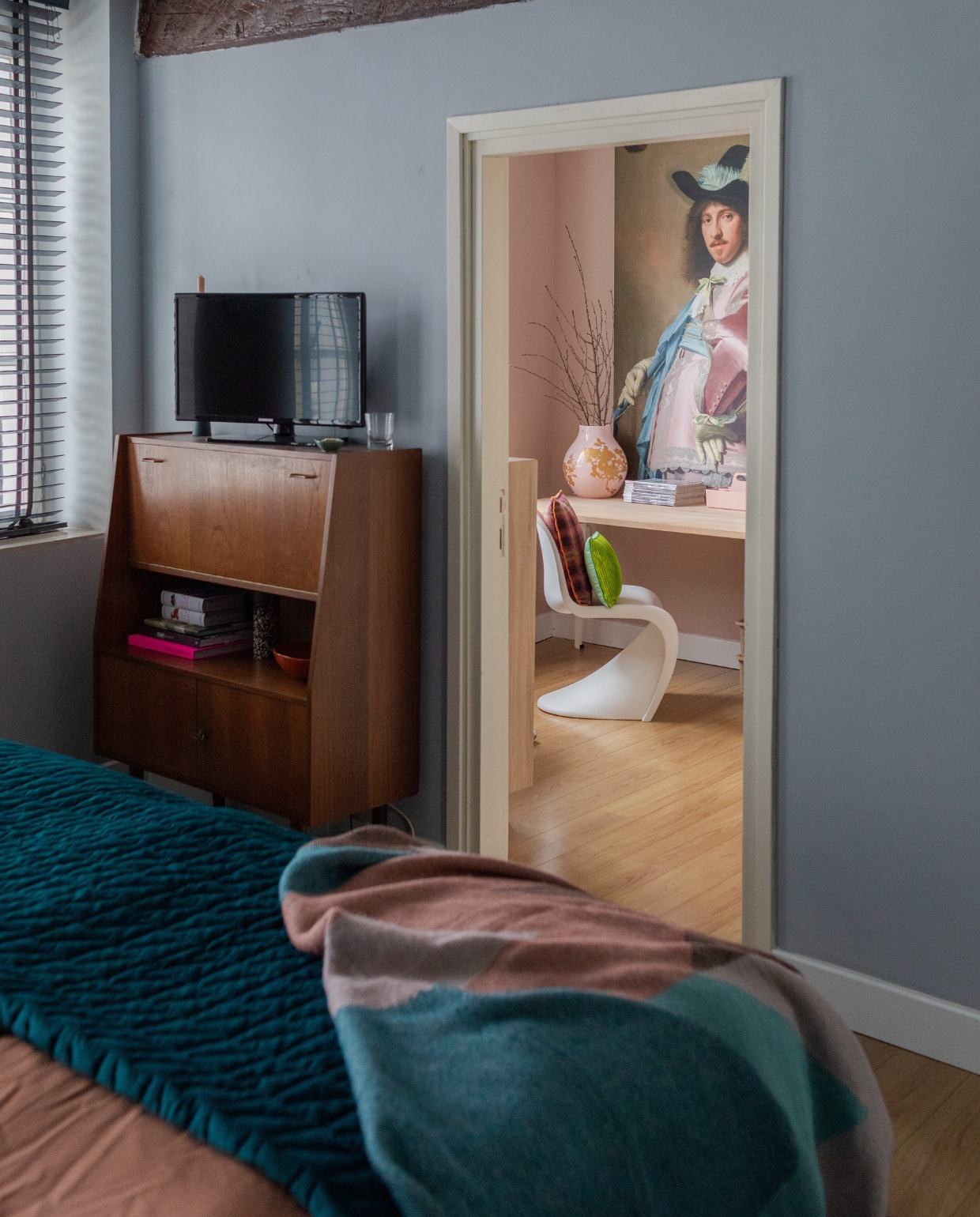 Dressoir Marktplaats, bruine vaas HKliving, schaal H&amp;M Home. Dekbedovertrek Kwantum, blauwe sprei Made, gekleurde sprei Sissy-Boy. Vaas Hella Jongerius voor Ikea. Opbergbak en stoel Panton van Vitra, kussens HKliving. Muurverf roze zelf gemengd van Karwei. Houten vloer en overig onbekend. vtwonen special binnenkijken 12-2023 | productie Cocofeatures | fotografie Anne den Haan