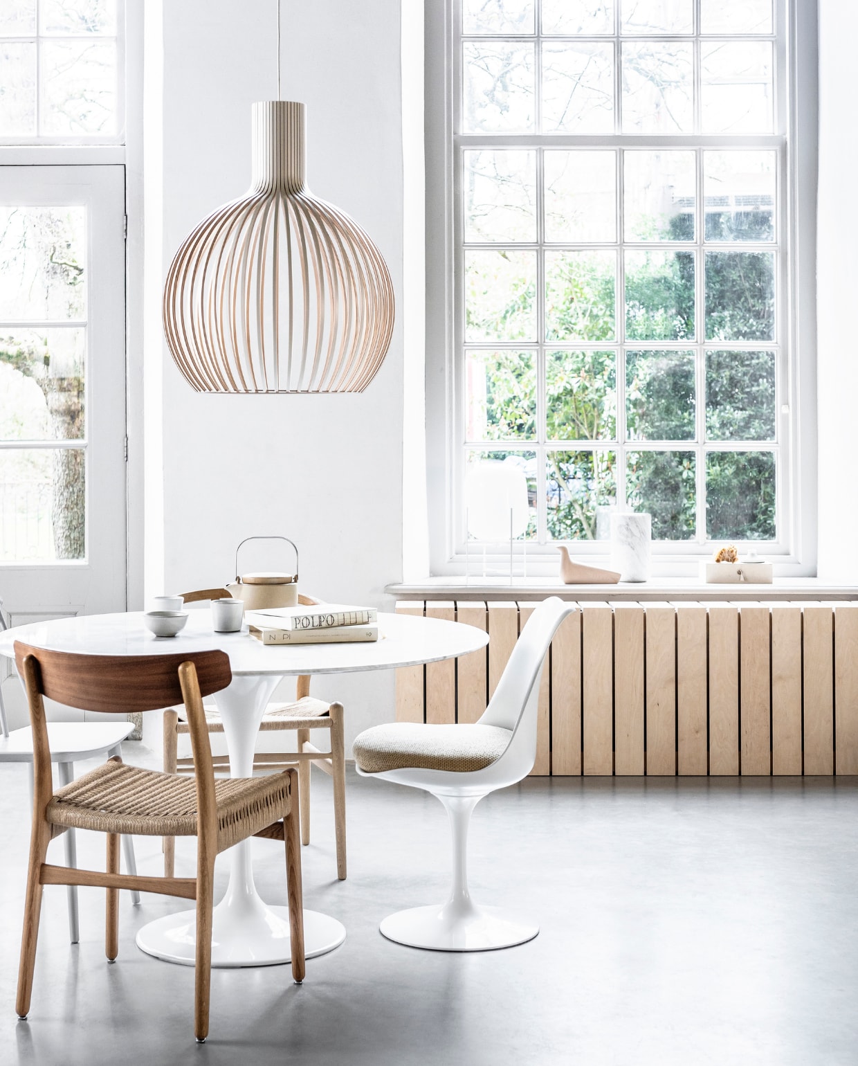 Ronde tafel Tulip met marmeren blad, ontwerp van Eero Saarinen, Ø 120 cm (eigenwijsdesign.nl). Houten hanglamp Octo van Secto Design, eikenhouten stoel Wishbone CH24, ontwerp van Carl Hansen, (misterdesign.nl). Stoel Tulip Chair, ontwerp van Eero Saarinen, houten stoel met gevlochten zitting, ontwerp van Hans J. Wegner, tafel Ring, ontwerp van Nendo Design, tafel Net, ontwerp van Benjamin Hubert (mobilia.nl). Mokken, kom, pastabord (suhka.nl). Spijlenstoel j77 in Dusty Grey van Hay, decoratieve houten vogel van Vitra, marmeren vaas Fajen van Zuiver (vtwonen.nl). Handgeblazen glazen tafellamp Oda, ontwerp van Sebastian Herkner (goeds.nl). Vloerlamp Alba (frozenfountain.nl). Vazen van keramiek van vtwonen, vloerkleed naturel knotted Fringes van vtwonen, 130x200 cm (hetkabinet.nl). Bank L’Authentique Michelle in stof Viking linnen (hamsmade.nl). Linnen kussen in kleur Cinnamon (bymolle.com). Overig privébezit. vtwonen 06-2019 | productie &amp; styling Kim van Rossenberg | fotografie Sjoerd Eickmans