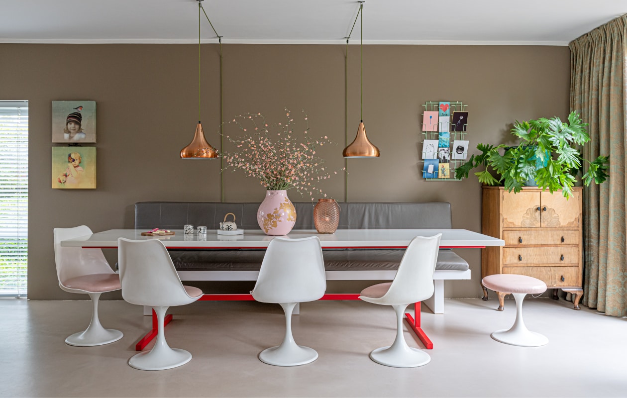 Muurverf Real Grey van Flexa. Schilderijen eigen ontwerp. Hanglampen en kaartenrek Marktplaats. Houten kast La Folie Antiek. Plantenbak en bank waren cadeaus, de tafel is eigen ontwerp. Stoelen en krukje Pastoe. Vazen van Hella Jongerius voor Ikea (roze) en Action. Theepotje kringloopwinkel, marmeren plaatje Sissy-Boy, porseleinen kopjes Henk Wolvers. vtwonen 04-2021 | styling Sharon Roest | fotografie Caroline Martinot