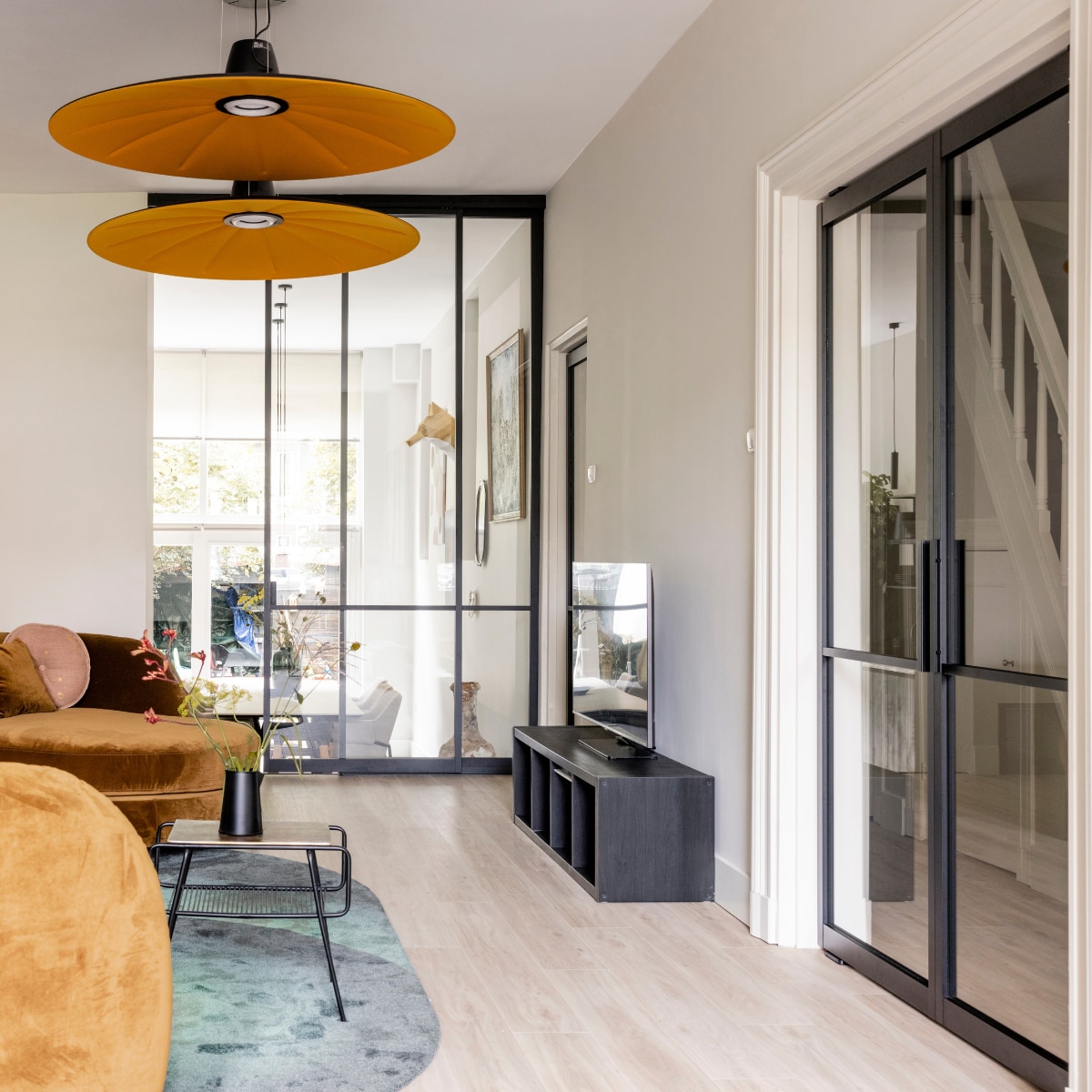 Verf muren Fine Cream Flexa, verf kast (naast de haard) Sandy Beach Flexa, wandpaneel met verlichting zelfgemaakt door Michiel Draaisma, behang op het paneel Canvas 313571 Eijffinger, pvc click vloer Blackjack Oak 2220 van Moduleo Woninginrichting-Aanhuis.nl, zwarte taatsdeuren, scheidingswand, schuifdeur GewoonGers, traptreden naar de keuken bekleed met blauwstalen neuzen en extreem off black leer uit de Stoer Chique collectie Upstairs, bank Connor Eijerkamp, vloerkleed Optical Eijerkamp, salontafel Glam Zuiver, hanglampen Lent Martinelli Luce, wandlamp op het wandpaneel Honore Lucide, vloerlamp achter de bank Buddy Eijerkamp, kussen (links op de bank) flowerbomb Muurmeesters, kussens onderdeel van bank Connor Eijerkamp, fluwelen kussenhoes (in het midden van de bank) Rembrandts kant, fluwelen kussen (rechts op de bank) kroonkraanvogel en melchior d’Hondecoeter Muurmeesters, rond roze kussen, zwarte vaas en houten kandelaar vtwonen. Overig privébezit. Weer verliefd op je huis seizoen 17 aflevering 5 | styling Frans Uyterlinde | fotografie Sonja Velda