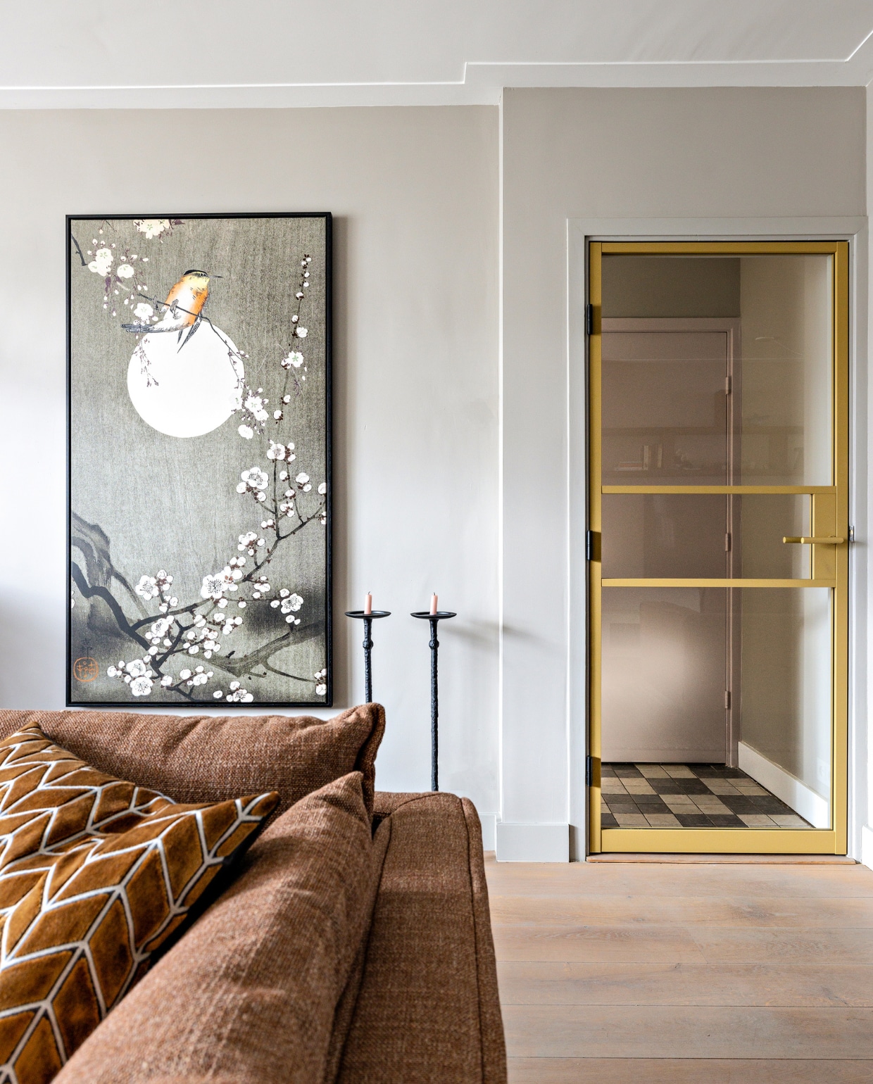 Deur in de kleur Gold Supreme GewoonGers, kunstwerk Zen Blooming Marja van den Hurk Werk aan de Muur, bank Cooper en vloerkleed Verona Eijerkamp, zwarte hoge kandelaren van Vestbjerg vtwonen, camel rechthoekig kussen Eijerkamp. Overig privébezit Weer verliefd op je huis seizoen 16 aflevering 1 | styling Fietje Bruijn | fotografie Sonja Velda
