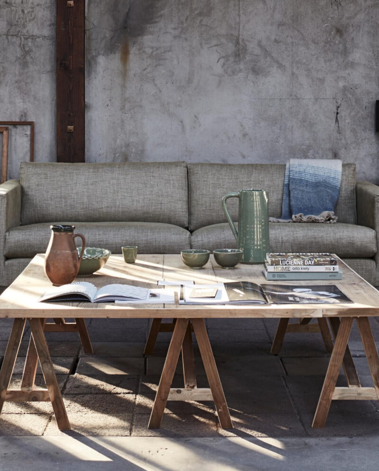Tafel 140x140x43 cm (bxlxh), op maat gemaakt (Combitex). 2,5-zitsbank Bruce, 185x75x93 cm (bxhxd) (Bodilson). Oude houten lijsten (Neef Louis). Grote flesvaas, kan met donkere rand (Van Dijk &amp; Ko). Manden per 2 (HKliving). Keramische kan, kom, espressokop, schaal, plaid 125x150 (De Weldaad). Groot opengeslagen magazine #mag59 no. 14 (Polspotten). Overig privébezit. vtwonen 04-2016 | styling Fietje Bruijn | fotografie Alexander van Berge