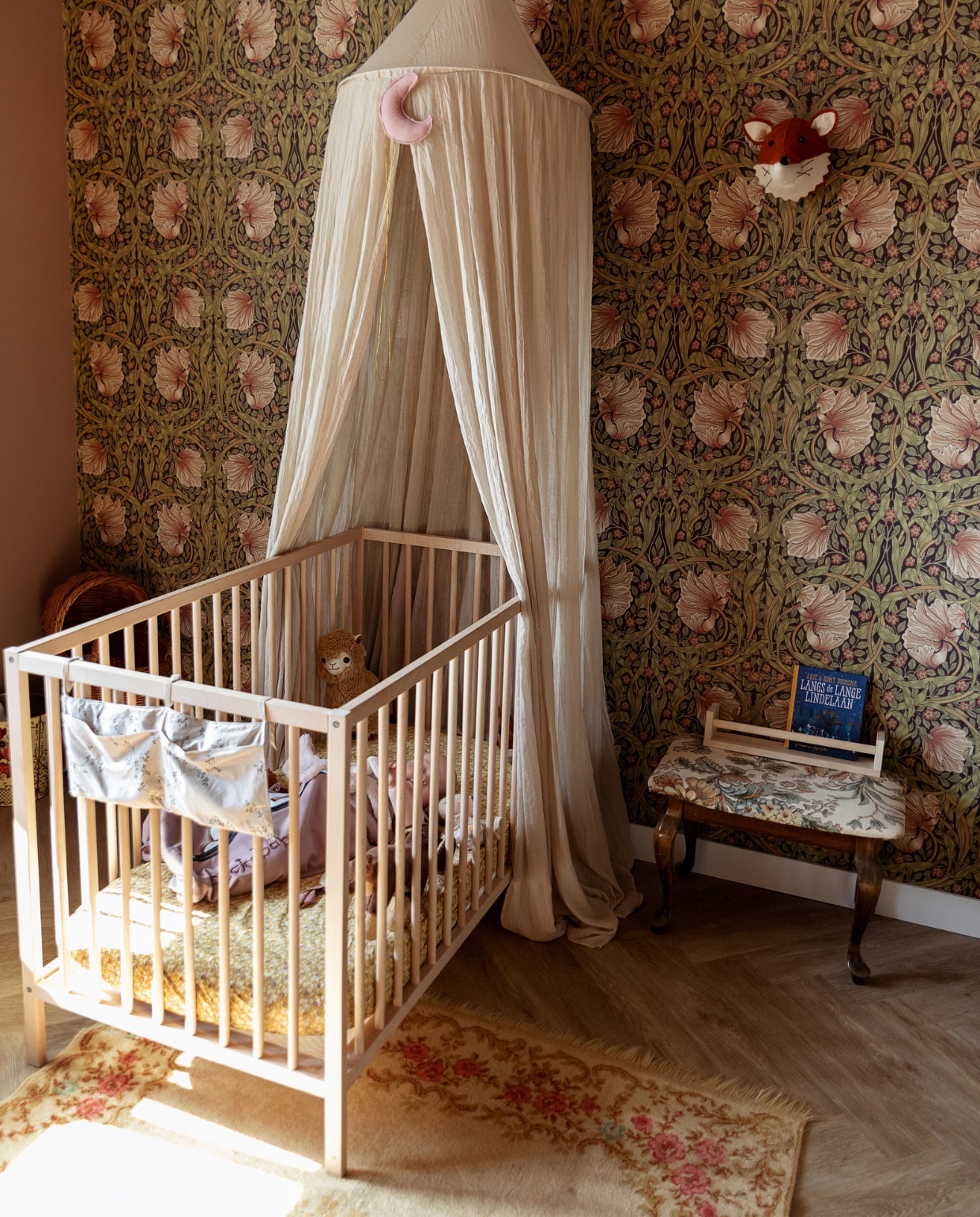 Bed Ikea. Klamboe Jollein via Studio Jules. Behang Morris &amp; Co. Kleed Marktplaats. Kruk kringloop. Houder Ikea. Vos aan wand Fiona Walker England. Knuffels Prénatal, beddengoed Zara Home. Overig privébezit. vtwonen 10-2021 | styling Ilona Jongepier | fotografie Dana van Leeuwen