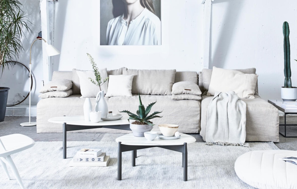 3-zits bank Michelle met loungegedeelte, 220x100x80 cm, exclusief bekleding, chaise longue 90x150x80 cm, exclusief bekleding, losse rugkussens 90x40 cm, exclusief bekleding (L’Authentique). Lamp Bellevue van &amp;Tradition, witte stoel Mademoiselle van Artek (Mobilia). Vloerkleed Ply van Muuto, 170x240 cm, ecru kussen van Muuto links, 50x50 cm (Design 020). Bijzettafels Heat met marmeren blad groot en klein, vierkante salontafel Terrace loud white, 90x90 cm (Linteloo). Foto op de muur Iris van Maarten Schröder in deze uitvoering (Wdstck). Grijze plantenpot (Homestede). Witte keramische plantenpot (My Deer’s). Wit kommetje, bordje van keramiek, 22 cm, houten platte schaal (HK Living). Hoge houten schaal, wit alpaca wollen kussen (Couleur Locale). Kussen ecru, 70x50 cm, plaid (De Weldaad). Poef Dimhult, glazen schaal met plant afkomstig uit een set van 3 uit de Ikea PS 2017 collectie (Ikea). Vaas links op de tafel (CK Ceramics). Overig privébezit. vtwonen 07-2017 | Styling Cleo Scheulderman | Fotografie Jeroen van der Spek