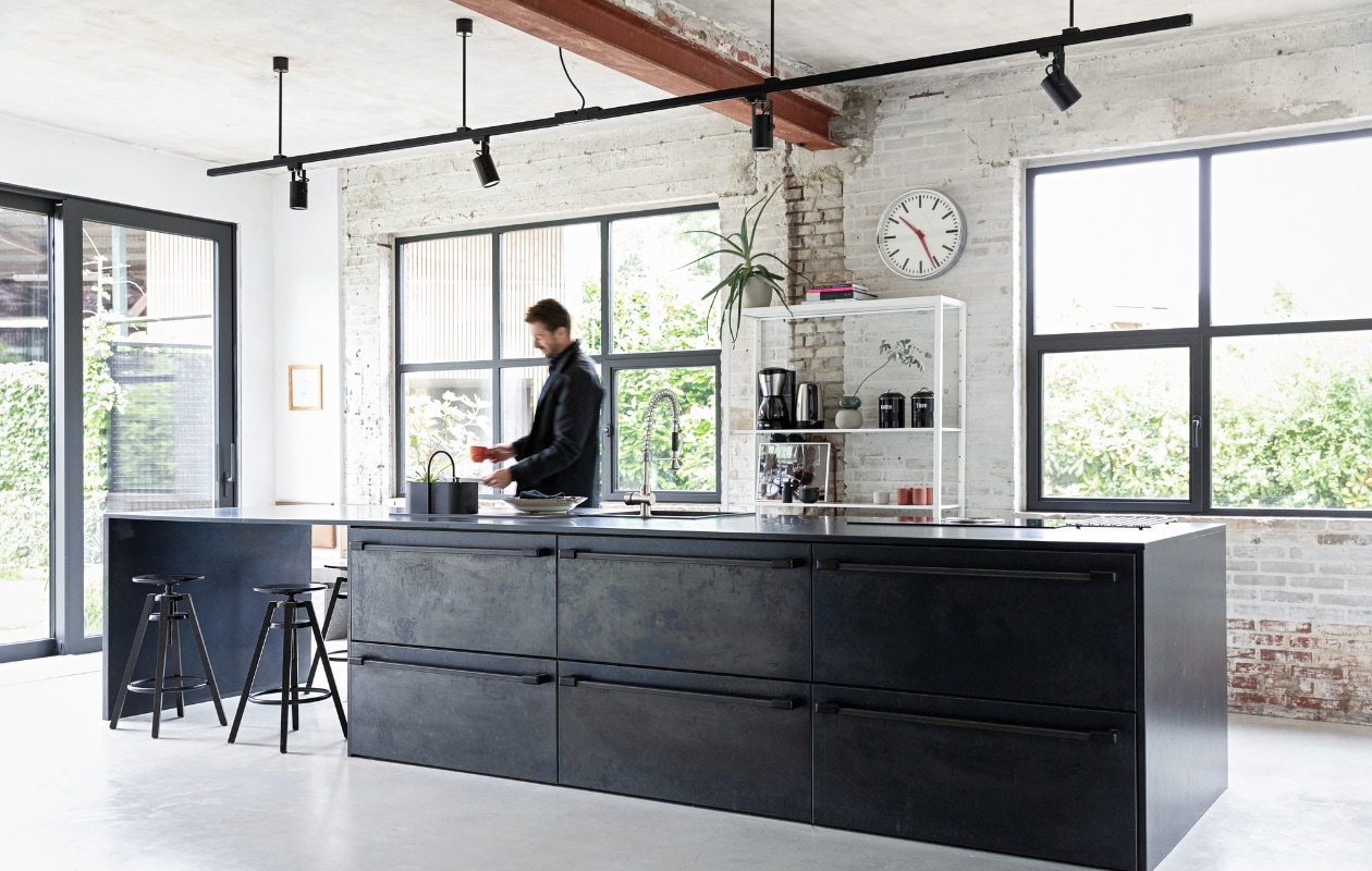 Keuken eigen ontwerp, binnenwerk op maat gemaakt door Marcel Hermans, beplating en werkblad van blauwstaal Schouren Metaal. Railarmatuur Venled. Toolbox Ferm Living. Krukken en open kast Ikea. Overig onbekend. vtwonen 01-2022 | styling Ilona Jongepier | fotografie Dana van Leeuwen