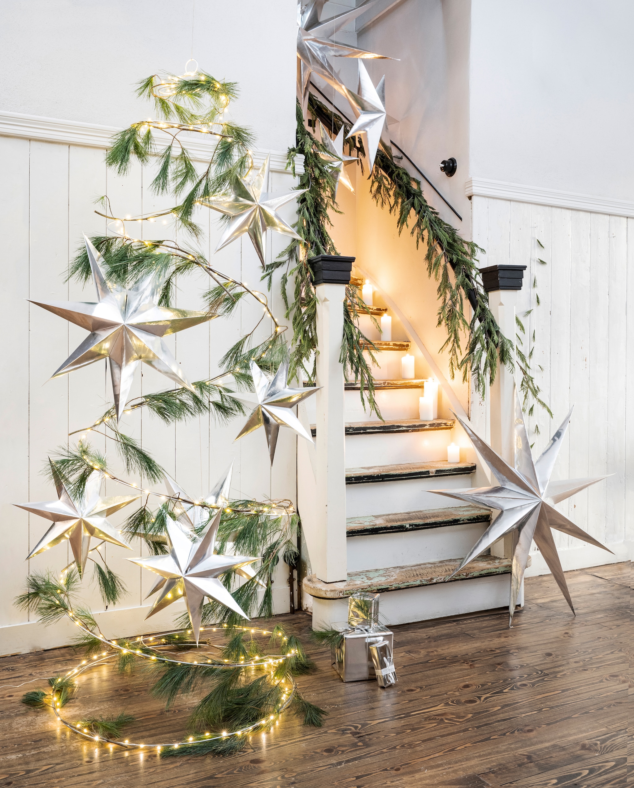 vtwonen collectie (Goudkleurige metalen spiraalkerstboom, 80 cm (Ø). Papieren sterren, 48 cm, 60 cm, 110 cm). Overig privébezit. vtwonen kerstbijlage 12-2023 | styling Tanja Saarberg | fotografie Stan Koolen