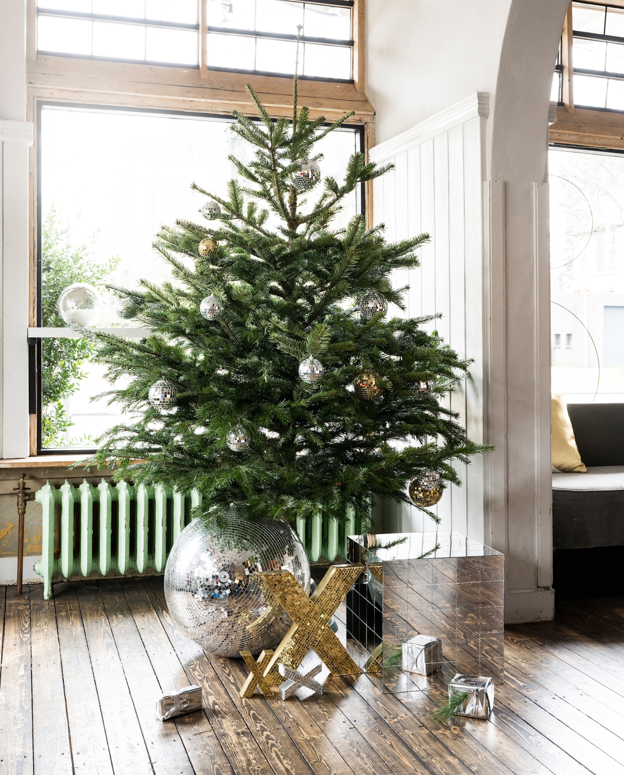 vtwonen collectie (Kerstballen in goud en zilver, 8 cm (Ø), 10 cm (Ø), 12,5 cm (Ø). Goudkleurige metalen mozaïekletter X, 35,5x4,5x33,5 cm (lxbxh). Gouden en zilveren metalen mozaïek- letter X, set van 3. Spiegel bijzettafel, 40x40x40 cm (lxbxh). Gerecycled katoenen kussen met halve maan, 45x45 cm, ook verkrijgbaar in zilver.)Overig privébezit. vtwonen kerstbijlage 12-2023 | styling Tanja Saarberg | fotografie Stan Koolen