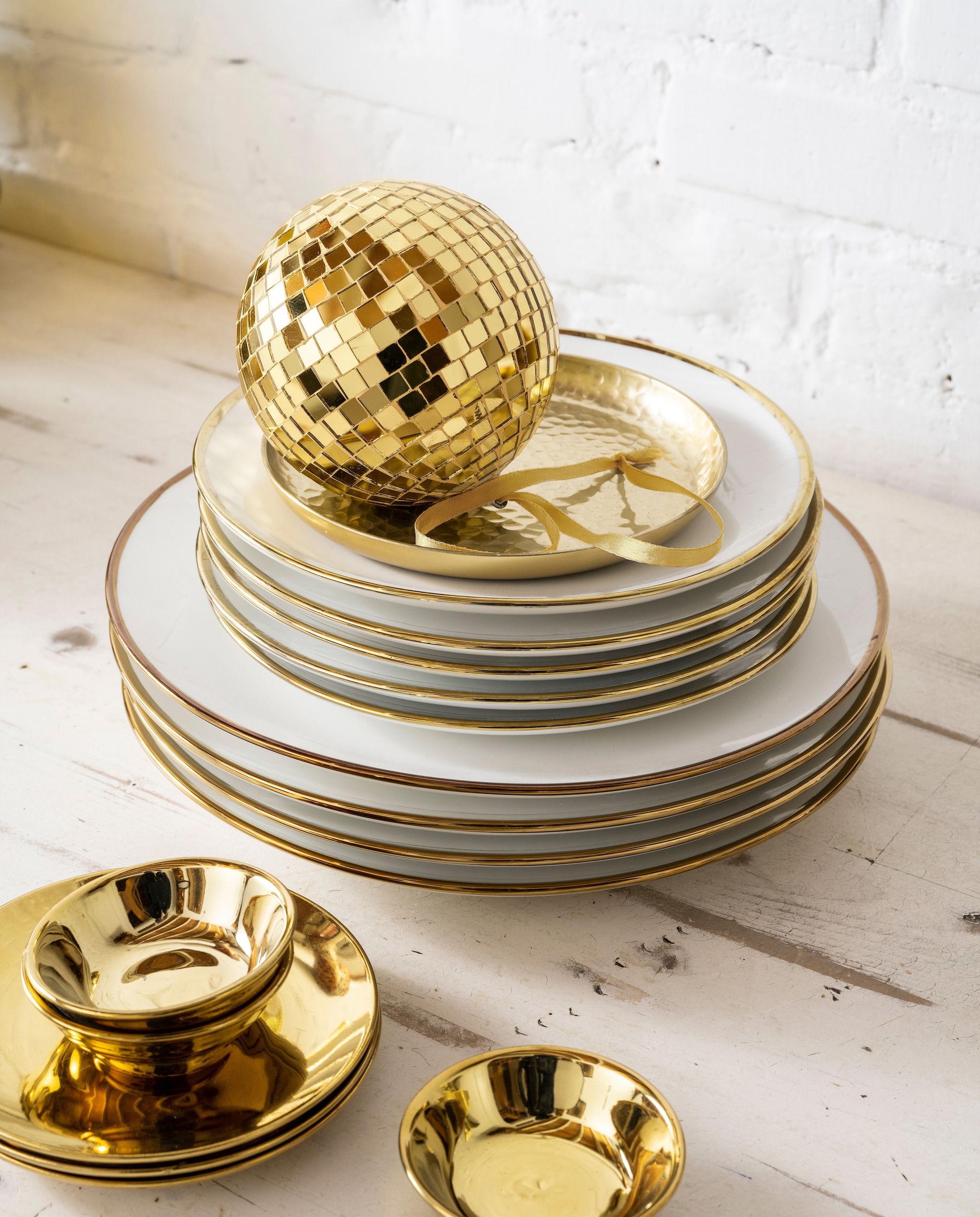 vtwonen collectie (Porseleinen borden, 20 cm (Ø), 25,5 cm (Ø). Gouden metalen schaal, 15 cm (Ø), ook in 12 cm (Ø) en 22 cm (Ø). Gouden porseleinen borden, 12 cm (Ø), set van 4. Gouden porseleinen theetips/sausschaaltjes, 7 cm (Ø), set van 4. Kerstbal.) vtwonen kerstbijlage 12-2023 | styling Tanja Saarberg | fotografie Stan Koolen