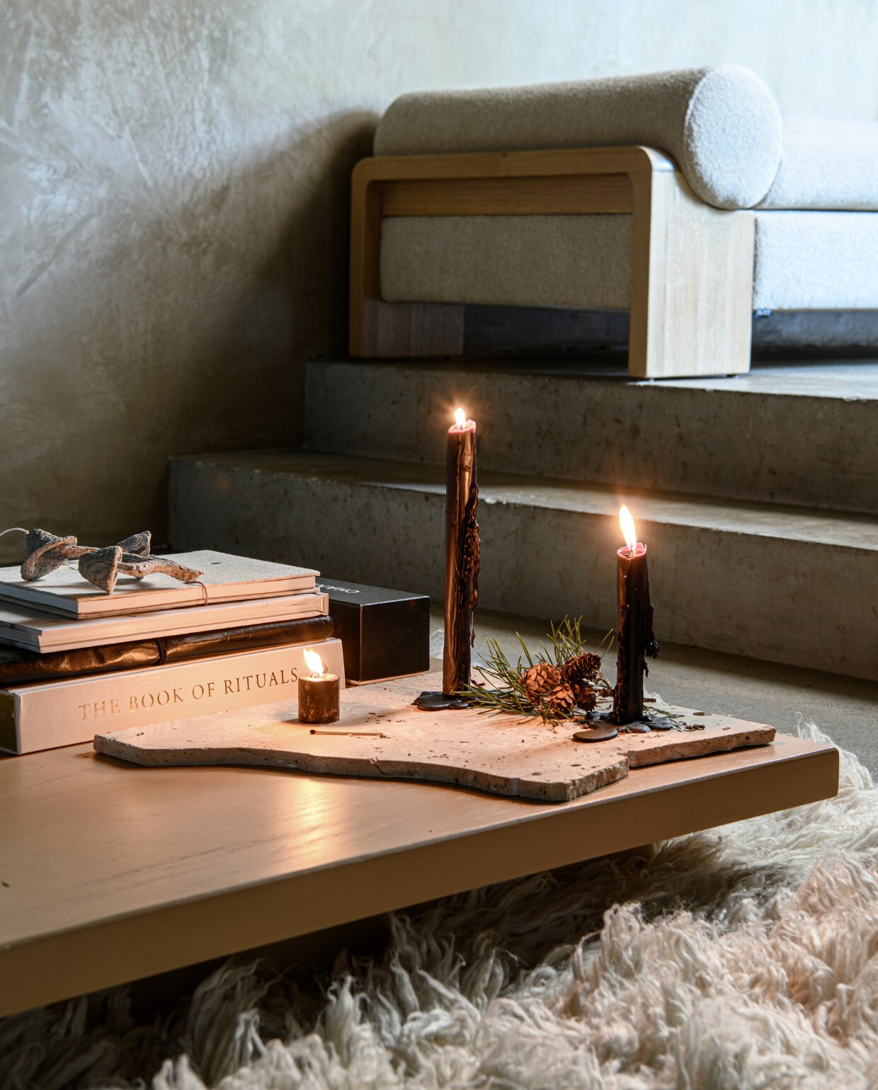 Vloerkleed Fluffy van HKliving, katoen en wol, 250 cm (Ø) € 1575,-, camelkleurige houten salontafel XL Plateau van HKliving, 60x200x12 cm (bxdxh) € 636,- (vtwonen.nl/shop). Wit koffietafelboek € 89,90 (rituals.com). Notitieboeken Dunes € 14,99, zwarte dinerkaars € 3,99 (thingsilike- thingsilove.com). Gebroken wit ornament Mushroom € 15,- (fermliving.com). Eiken daybed Dya uit eigen collectie van Loods 5, 180x75cm (lxb) € 995,-(loods5.nl). vtwonen bijlage kerst 2023 | styling Marit Saladini | fotografie Louis lemaire