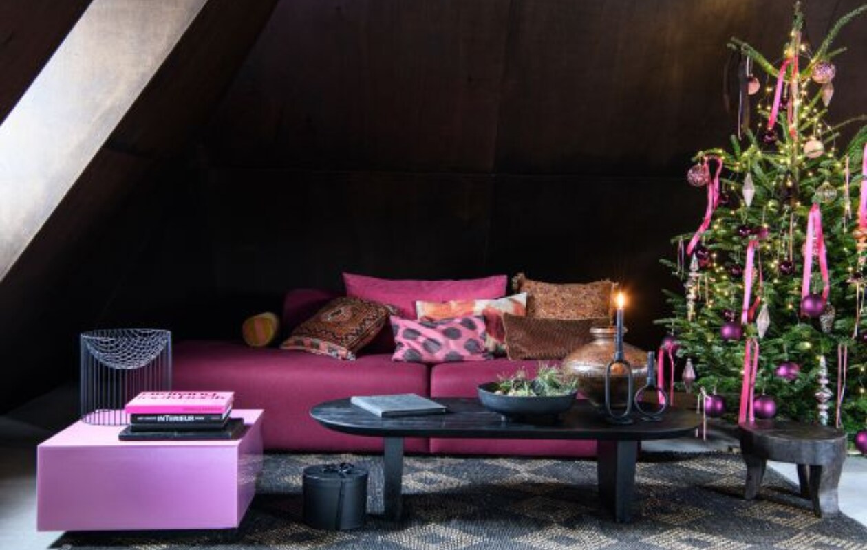 Roze salontafel Mirror Block van HKliving, 60x60x32 cm (bxdxh) € 349,- (vtwonen.nl/shop). Vloerkleed Diamant van HKliving, jute en zacht katoen, 240x150 cm € 374,- (dotshop.nl). Zwarte mangohouten salontafel Bullnose, 140x60x35 cm (lxbxh) € 609,-, koperen oude waterpot € 360,-, zwarte kruk Tribal € 204,- (rawmaterials.eu). Zwarte schaal Plateau Paper uit eigen collectie van Loods 5 € 29,95 (loods5.nl). Zwarte stenen kandelaar Bobbi, klein € 9,99 en groot € 14,95 (thingsilikethingsilove.com). Modulaire sofa Mags, in stof Divina Melange 3 by Kvadrat, kleurcode 620, 256x135,5x67 cm (bxdxh) vanaf € 3150,- (hay.nl). Kussens gemaakt van reststof (markt). Perzisch tapijtkussen (marktplaats.nl). Gebloemd kussen van Madam Stoltz € 18,- (deens.nl). Frambozen satijnlint, rol 32 meter € 3,49 (lintenkopen.nl). Framboosroze kunststof kerstballen, 10 cm (Ø), set van 4 € 14,24 (blokker.nl). Glazen piek Pennystone € 12,99, overige kerstballen vanaf € 1,99 (intratuin.nl). Overig privébezit. vtwonen bijlage kerst 2023 | styling Marit Saladini | fotografie Louis lemaire