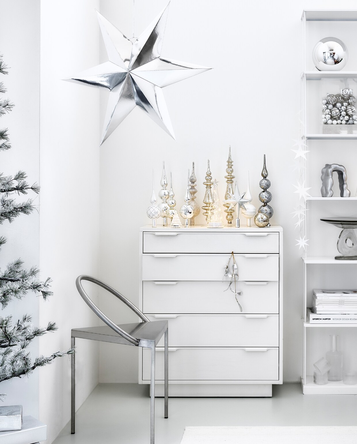 Witte mdf ladekast, 74x33x88 cm (bxdxh) € 995,-, rechthoekige plexiglas stolp met linnen voet, 20x12x30 cm (bxdxh) € 89,95 (hkliving.com). Wolmix tapijt, 160x230 cm € 199,- (zarahome.com). Rvs stoel Triangolo, 48x40x72 cm (bxdxh) € 1185,- (framacph.com). Zilverkleurige papieren ster, 60 cm € 19,95, aluminium ornament Morf van Ferm Living € 135,-, glazen etagère Damo van Ferm Living € 239,-, geribbelde glazen karaf van Ferm Living € 39,-, geribbelde glazen van Ferm Living € 39,- (vtwonen.nl/shop). Mistletoe € 22,50 (bungalow.dk). Pieken van links naar rechts: 1, 4, 9 van House of Seasons € 12,95 (bol.com). 2, 3, 5, 8, 10 vanaf € 5,85 (allesinwonderland.nl). 6 en 7 van House of Seasons vanaf € 24,95 (fonq.nl). Geribbelde ledkerstboom Lucy van Sirius, set van 2 € 28,75, glazen ledboom Sweet van Sirius € 23,95, papieren sterrenslinger van Räder € 16,95, kerstboom Alfi Tree van Sirius, 150 ledlampjes, 180 cm (h) € 275,- (two-gether.nl). Glazen kerstbal van House of Seasons € 2,95 (fonq.nl). Zilveren bal van House of Seasons, 25 cm (Ø) € 17,95 (bol.com). Kleine ballen van House of Seasons, set van 24 € 14,95 (bol.com). Geribbelde ballen, set van 2 € 7,99 (hm.com). Kersthanger love € 5,50 (kerstenbv.nl). Inpakpapier € 2,95 (vliegerpapier.nl). Overig privébezit. vtwonen bijlage kerst 2023 | styling Kim van Rossenberg | fotografie Sjoerd Eickmans