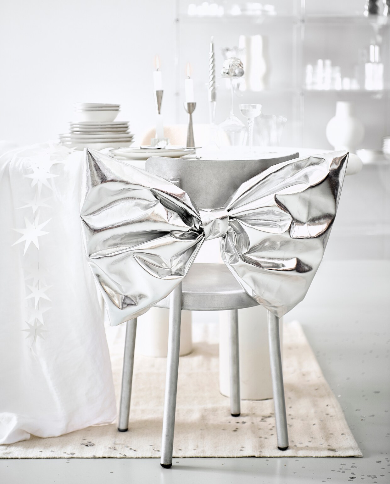 Eettafel Bloomstone, mdf met lichte ecoplaster finish, 230x117x78 cm (lxbxh) € 1530,- (richmondinteriors.nl). Aluminium stoel Tasca € 680,-(framacph.com). Porseleinen servies van vtwonen vanaf € 7,95, metalen kandelaars Metal van vtwonen vanaf € 16,95, bestek Montreux van Sola, 50-delig € 115,99 (vtwonen.nl/shop). Wijnglas € 22,99, wit linnen tafelkleed € 69,99, wollen tapijt, 160x230 cm € 199,-, glazen kandelaar vanaf € 9,99 (zarahome.com). Gedraaide kaarsen, set van 6 € 15,95 (kunstindustrien.dk). Witte kaarsen, per stuk € 1,- (hema.nl). Sterrenslinger € 16,95 (two-gether.nl). Tweedehands wijnglas € 0,20 (kringloopwinkel). Zilveren confetti € 9,20 (partywinkel.nl). Zilverkleurig inpakpapier € 2,95 (vliegerpapier.nl). Zilveren stof, per meter € 15,- (stof.nl). vtwonen bijlage kerst 2023 | styling Kim van Rossenberg | fotografie Sjoerd Eickmans