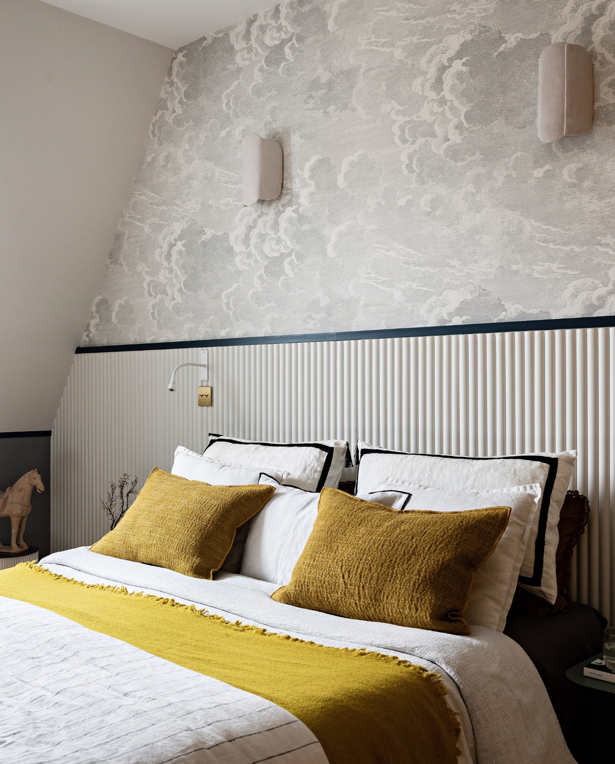Behang Nuvolette Cole &amp; Son, lambrisering Orac Decor, bedlampen Modelec, nachtkastjes Sklum, beddengoed Maison de Vacances, kussens Olivier Desforges, paard souvenir uit Londen. Overig onbekend. vtwonen 12-2023 | productie AC Scoffoni | styling Marie-Maud Levron | fotografie Yann Deret | tekstbewerking Merel van der Lande