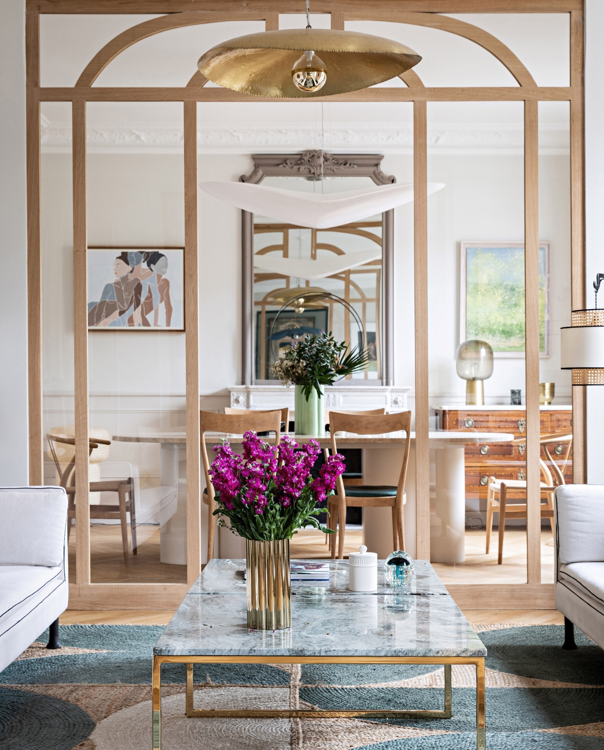 Stenen tafel en salontafel op maat gemaakt door Bateaumagne. Stoelen rommelmarkt in Normandië, hanglamp Céline Wright, schilderij links Faustine Badrichani, schilderij rechts Antoine Vit. Ladekast en spiegel erfstuk. Gouden vaas en glazen vaas H&amp;M Home. Groene vaas India Mahdavi, vloerkleed Rocky van Élitis, gouden hanglamp Brass 95 van Paola Navone voor Gervasoni. Overig onbekend. vtwonen 12-2023 | productie AC Scoffoni | styling Marie-Maud Levron | fotografie Yann Deret
