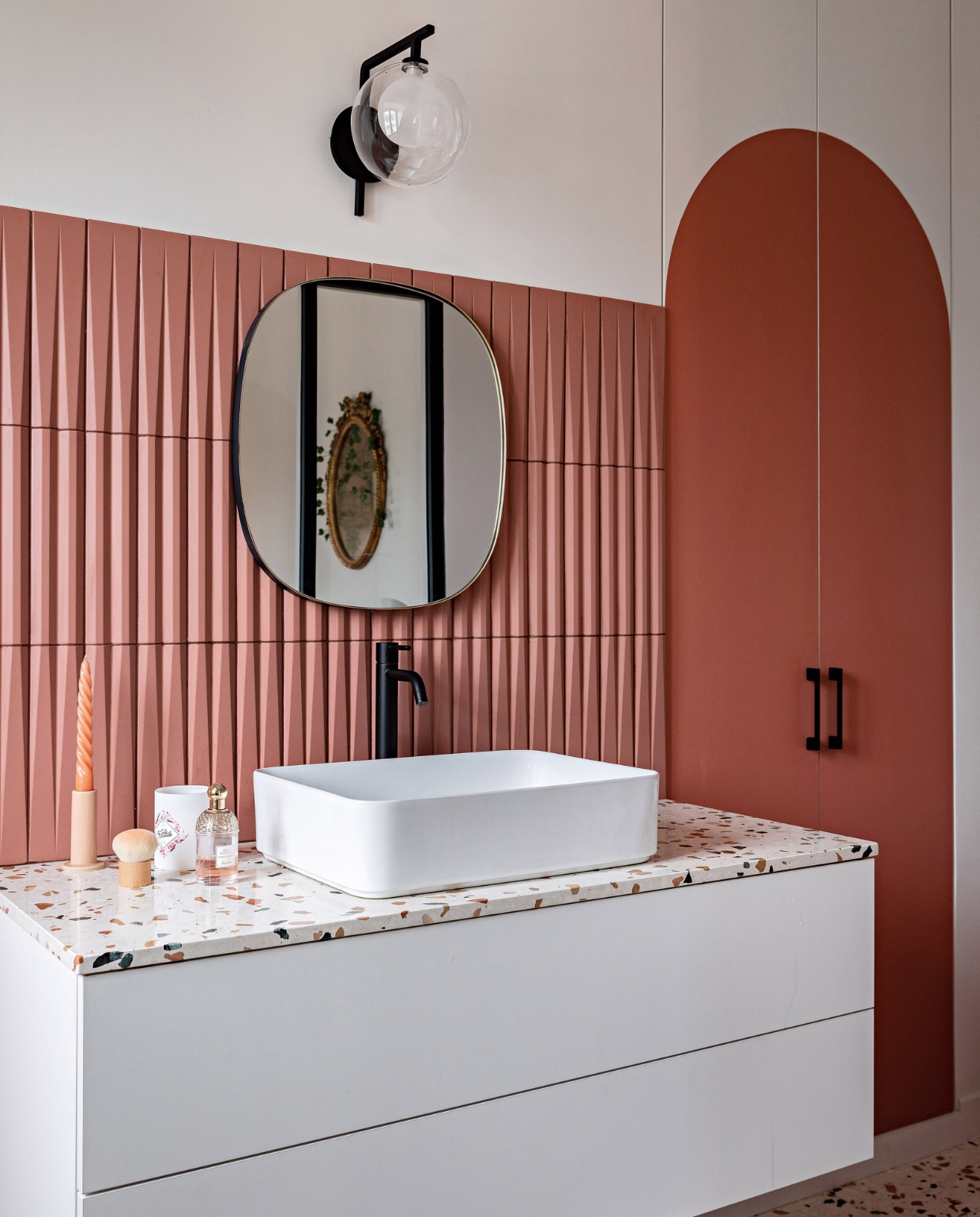 Wandpaneel Orac Decor, verf deuren Red Earth van Farrow &amp; Ball. Wastafelmeubel en terrazzovloer Ceramica. Wastafel Credenza, spiegel Leroy Merlin, wandlamp Bhv Marais, kraan Gessi. Overig onbekend. vtwonen 12-2023 | productie AC Scoffoni | styling Marie-Maud Levron | fotografie Yann Deret | tekstbewerking Merel van der Lande