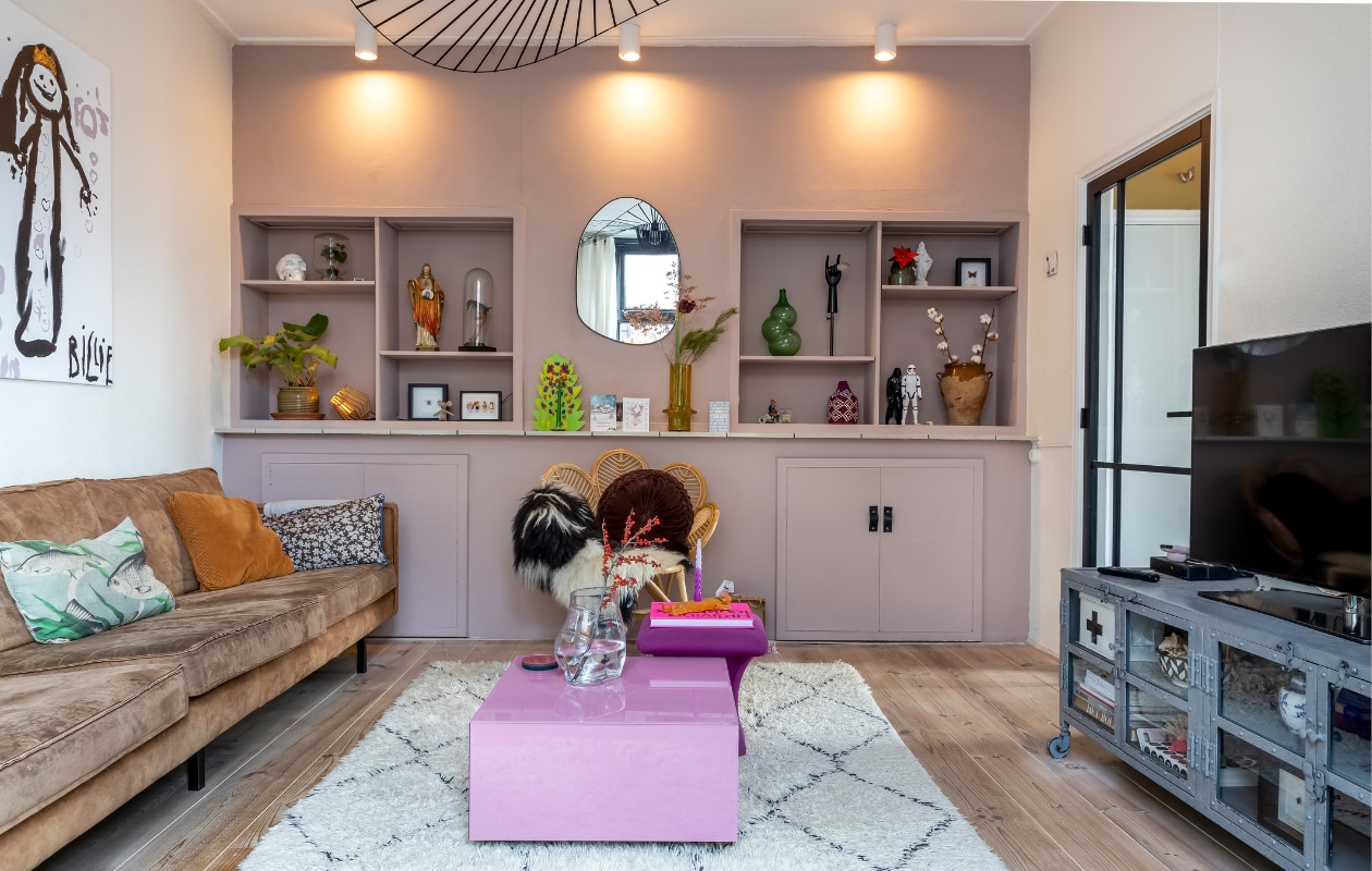Gebloemd kussen, salontafel en glazen vaas HKliving. Rolkast onder de tv Quip &amp; Co. Spiegel Zara Home. Spots Karwei. Hanglamp cadeau gekregen. Vloer Bebo Parket. Glazen deur Stunthandel Doldersum. Keulse pot en terracotta vaas vintage. Zwarte lijstjes demuseumwinkel.com. Stolpen zelfgemaakt. Okergele vaas Puur Petra. Groene vaas Klaas Kuiken. Rood-wit geruit mandje souvenir uit Marrakech. Zie ook eerste pagina’s. vtwonen 13-2023 | fotografie Henny van Belkom
