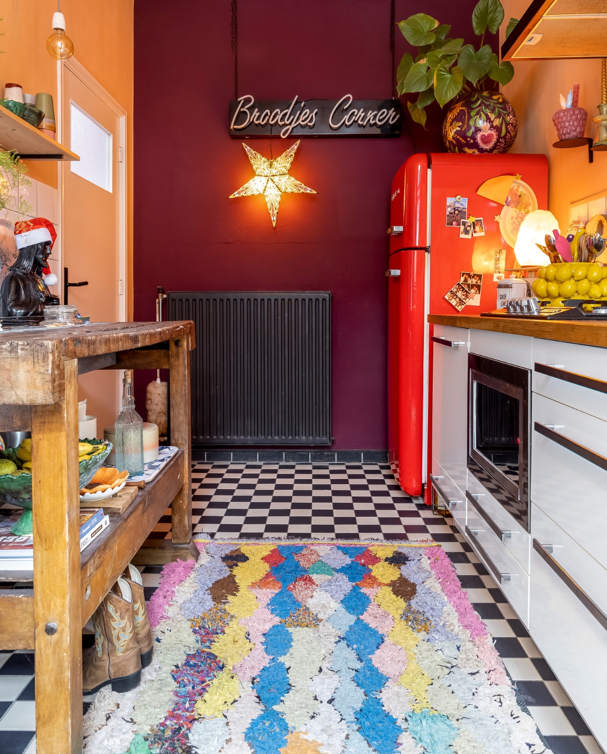 Jezusbeeld kringloopwinkel. Vloertegels Gamma. Kleed uit Marrakech. Keuken Ikea. Rode koelkast Smeg. Muurverf Bordeaux Leaf van Flexa. Verlichte ster Rok &amp; Billie. Bord Broodjes Corner vintage. Bloempot op koelkast zelf geschilderd. Frambozenpot Intratuin. Citroenschaal Des Pots. vtwonen 13-2023 | fotografie Henny van Belkom