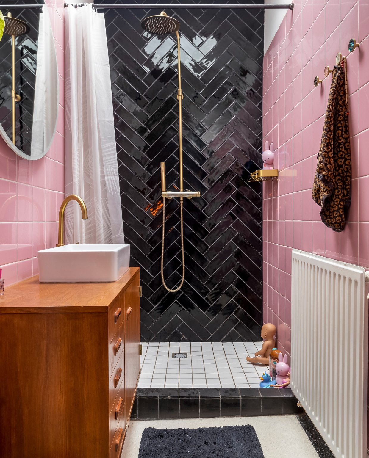 Roze tegels Hornbach. Zwarte tegels tegelwinkel.nl. Kranen en badmat Praxis. Wastafel VidaXL. Kast tweedehands. Spiegel Marktplaats. Douchegordijn Jysk. Schap en kledinghaken AliExpress. Nijntje-shampoo Kruidvat. vtwonen 13-2023 | fotografie Henny van Belkom