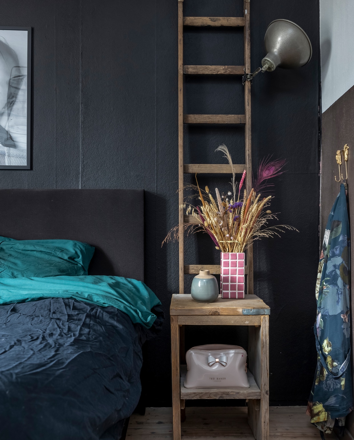 Beddengoed Ikea. Ladder zelfgemaakt van een vintage brandweerladder. Tafel zelfgemaakt. Blauwe vaas kringloopwinkel. Roze vaas Puur Petra. Lamp erfstuk. Kledinghaken Kwantum. Muurverf 1d1e1f van Flexa. vtwonen 13-2023 | fotografie Henny van Belkom