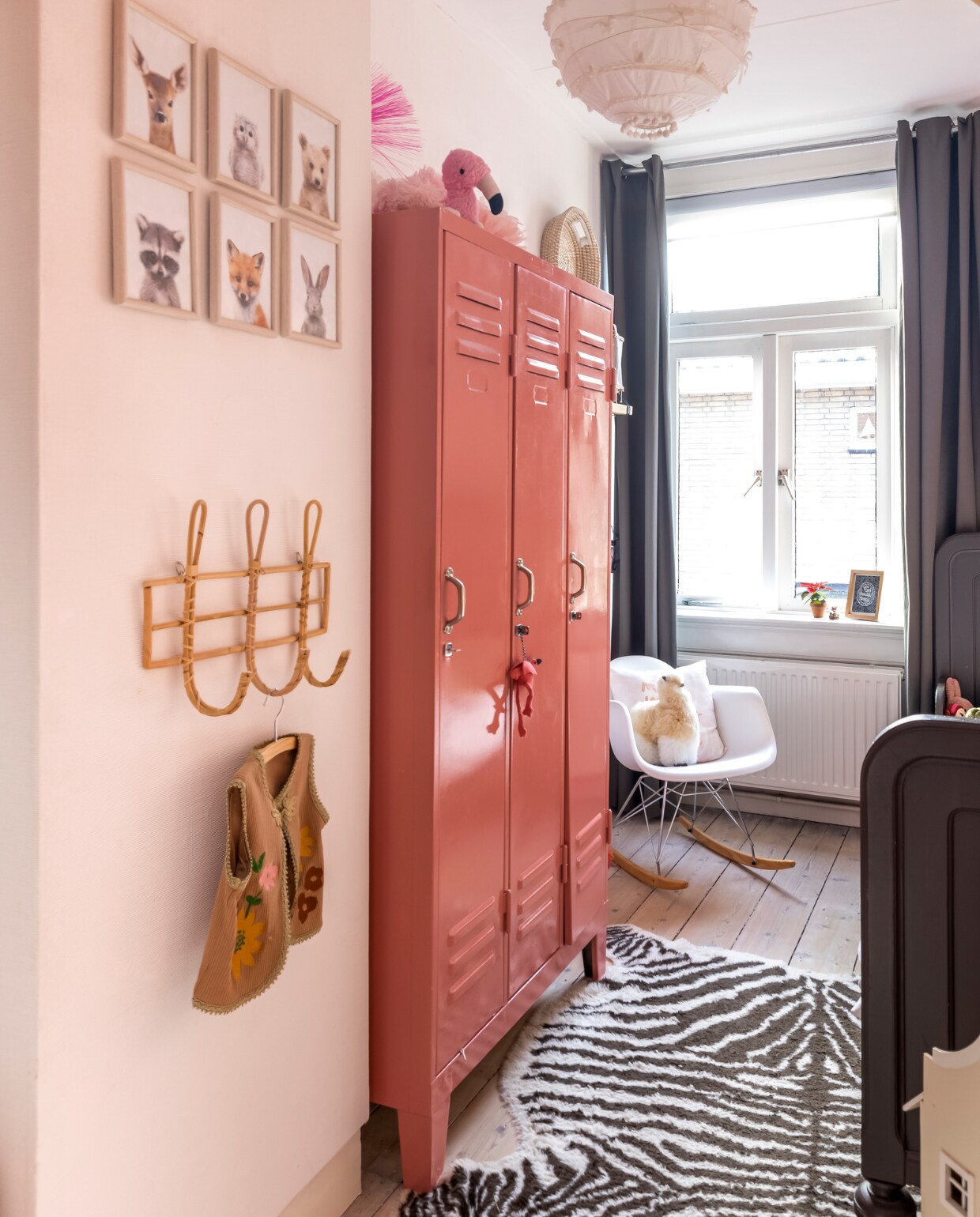 Verf muur onbekend, vergelijkbare kleur Chemise van Little Greene. Kapstok Kwantum. Gilet Ammehoela. Dierenportretten en plafondlamp zelfgemaakt. Lockerkast vintage geverfd met Flower Bulb 3019 van Flexa. Flamingo Sissy-Boy. Schommelstoel Marktplaats. Zebrakleed en gordijnen Ikea. Bed Vintage. vtwonen 13-2023 | fotografie Henny van Belkom