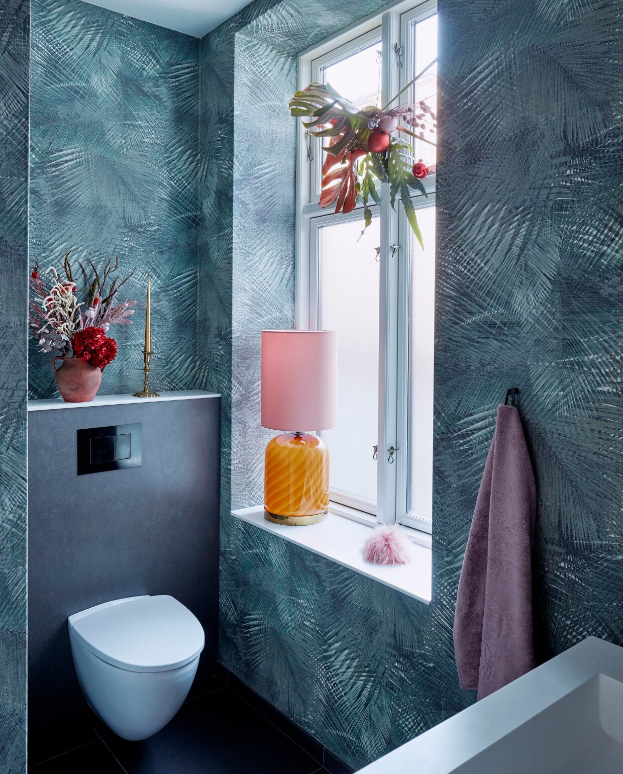 Behang Tapetforum. Glazen lamp Tommaso Barbi. Lampenkap Camille Helene. Bloemstukken zelfgemaakt. Handdoek Georg Jensen Damask. Kandelaar en terracotta vaas vintage. Roze scrunchie Mischa Studio. vtwonen kerstspecial 2020 | productie Living Inside | fotografie Martin Sølyst