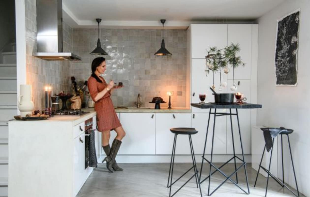 Vloer Tav Microcement, muurverf Signaalwit, wandtegels zelliges in Naturel van Household Hardware, keuken Ikea, frontjes Faktum. Grepen en hanglampen Loods 5. Bartafel en -krukken Lof, schalen en potten Raw Materials. Witte vaas, taartschaal en gietijzeren pan Fonq. Kaarsen en kaarsenstandaards Intratuin. Theedoek H&amp;M Home, percolator Bialetti, glazen Dille &amp; Kamille, ornamenten Casa, wanddoek Old Dutch Canvas met Kerstboom in het bos van More Than Canvas. Overig onbekend. vtwonen 13-2023 | productie Insidehomepage | fotografie Louis Lemaire