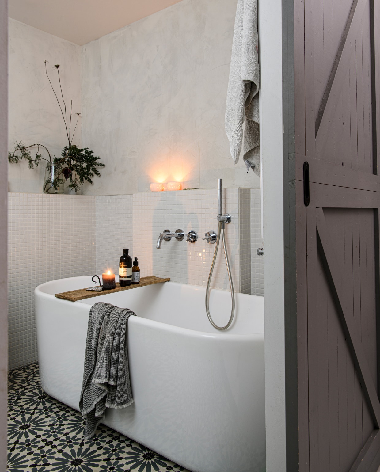 Muurverf Marrakech Walls Ashes van Pure &amp; Original, wandtegels Ton Scholten, vloertegels Designtegels. Vazen en kandelaars kringloop. Bad Sanidirect, kranen Ben Sanitair, houten plank Xenos. Zeeppomp en badschuim Dille &amp; Kamille. Kaars Casa, handdoeken H&amp;M Home. vtwonen 13-2023 | productie Insidehomepage | fotografie Louis Lemaire