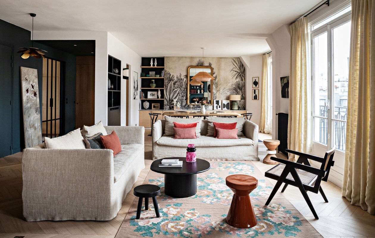 Bank en kussens Maison de Vacances. Overige kussens Caravane. Salontafel en terra kruk La Redoute. Zwarte kruk The Corner Studio. Kleed Le Monde Sauvage. Vergelijkbare zwarte fauteuil Casa Gitane. Gordijnstof Elitis. Vergelijkbare verfkleur Denim van Carte Colori. Hanglampen Caravane. Eiken tafel Oasis van Maison Sarah Lavoine. Stoelen Carl Hansen &amp; Søn. Hanglamp Maison Paloma. Spiegel vintage. Behang Le Monde Sauvage. Witte vaas HKliving. Lamp met groene voet Zara Home. Schilderijen Floating House Collection. Vloerkleed Elitis. Overig onbekend. vtwonen 12-2022 | styling Marie-Maud Levron | fotografie Yann Deret