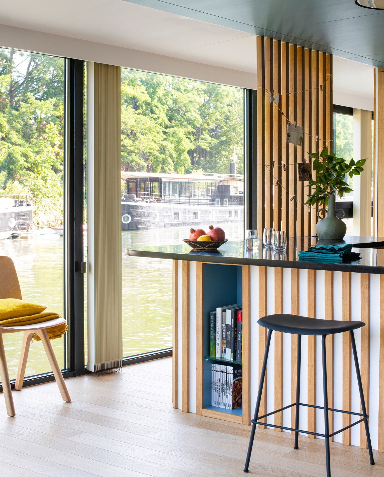 Muurverf Grey Stone en keukenblad geverfd in Black Corian van Little Greene, barkrukken Muuto, lampen LP Slim Round Louis Poulsen, vloer gelakt met Oak Natural, servetten Haomy, vaas Serax, servies Am.pm en Zara Home. Overig onbekend. vtwonen 10-2022 | styling Marie-Maud Levron | fotografie Patrick Sordoillet