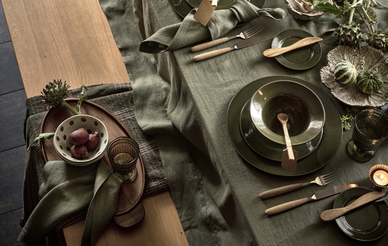 FSC-gecertificeerd eikenhouten eettafel Base, vanaf 200x90x77 cm (lxbxh), FSC-gecertificeerd eikenhouten eetkamerbank Base, 140x40x4x45 cm (studio-henk.nl). Wit geoliede eikenhouten eetkamerstoel Drawn HM4 met armleuning (andtradition.com). Houten eetkamerstoelen met rugleuning van touw (dutchbone.com). Houten kandelaren (zuiver.com). Grote aardewerken kan Henry, kleine kan koolblad, kom koolblad, schaal koolblad, dinerborden Grawa, ontbijtborden Grawa, soepkommen Grawa, schotels Grawa, houten dienblad, lange houten lepels, houten botermesjes, houten schaal op voet, gestipte kommen (nordal.com). Bestekset Gent, rvs met houten handvat, 16-delig (dille-kamille.nl). Wijnglazen (zarahome.com). Kunstdennentakken in kan, mini kunstdennenboom in pot (mr-plant.nl). Linnen tafelkleed kleur Sage, linnen servetten kleur Sage (timelesslinen.com). Katoenen plaid van Madam Stoltz (deens.nl). Led-kaarsen met knijper, set van 4 (piffany.eu). vtwonen 13-2023 | styling Cleo Scheulderman | fotografie Jeroen van der Spek