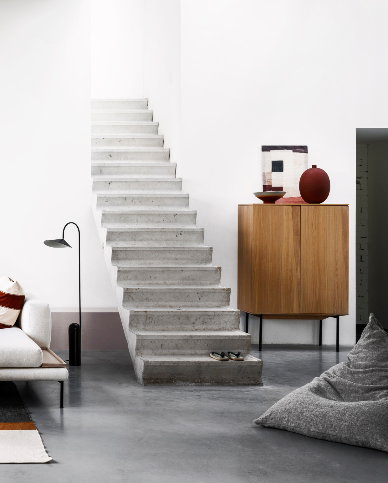 zwarte vloerlamp Arum met stenen voet van Ferm Living (kolkenkolk.nl). Bank met chaise longue van Bolia, 310x185 cm (bxd), kast van geolied eiken met stalen poten van Bolia, 155x100x45 cm (hxbxd), schaal, vaas (boer-staphorst.nl). Kommen van HKliving, ronde metalen bijzettafel Place van Ferm Living (vtwonen.nl). Vloerkleed Nash van grote wollen deken, 260x240 cm (libeco.com). Zitzak van linnen stof met Japans dessin, 135x90 cm (maomi.de). vtwonen 05-2020 | styling Marianne Luning | fotografie Stan Koolen