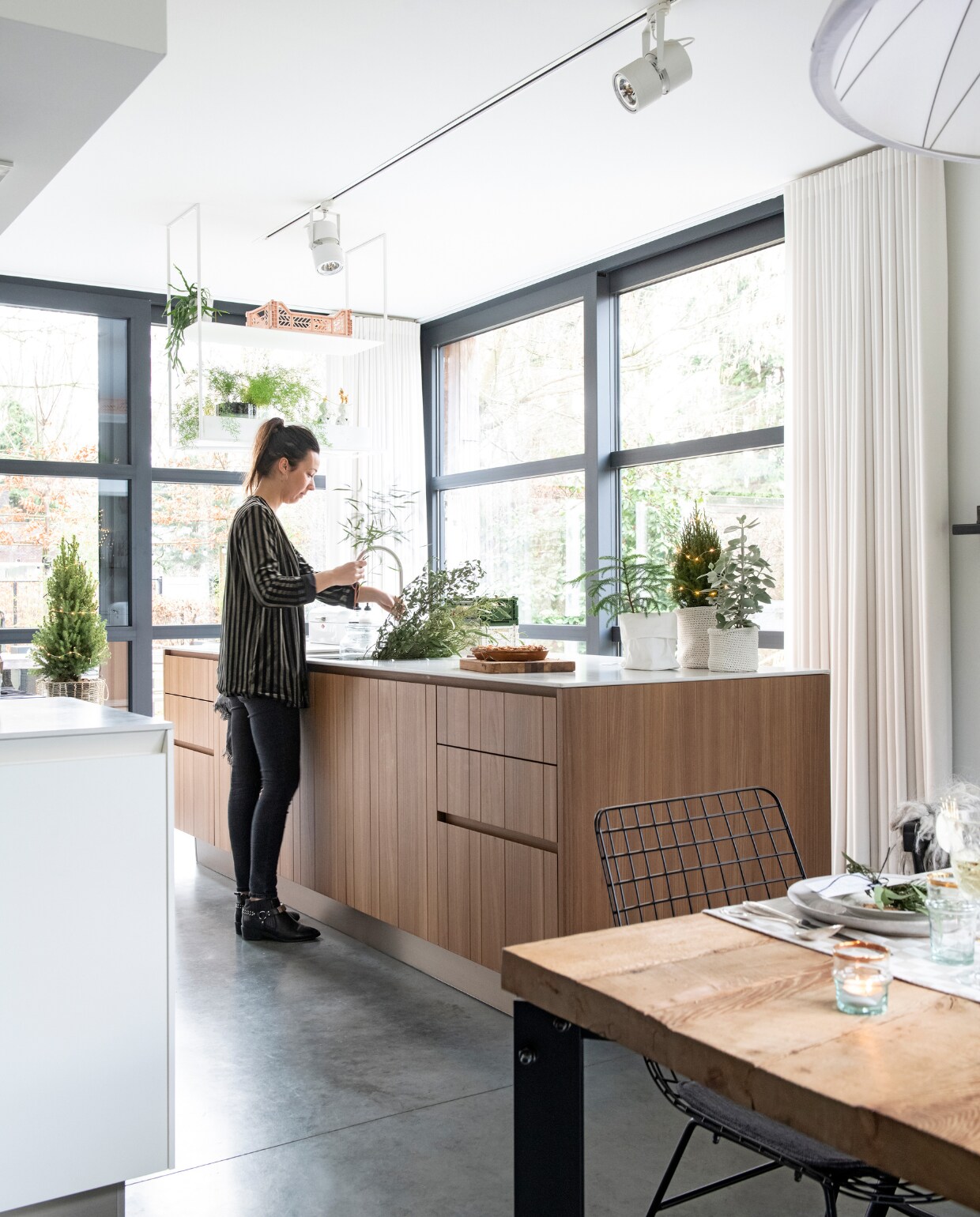De keuken in olmen houtfineer is ontworpen en uitgevoerd door Gay Jongen. Kozijnen van staal. Metalen plafondrek, houten broodplanken en eettafel gemaakt door Robuust Maatwerk. Draadstoel HKliving vtwonen 12-2019 | styling Babs Dols | fotografie Louis Lemaire | productie insidehomepage
