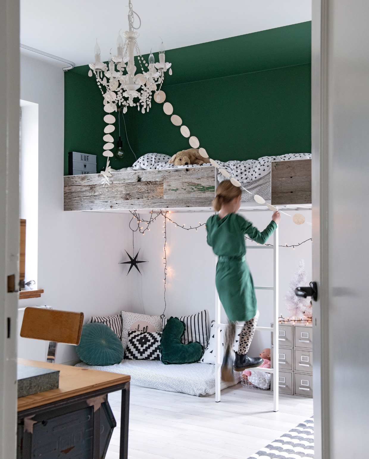 Pleun slaapt hoog in de lucht, in een bed gemaakt van schuurhout en staal, met een geïntegreerde trap. Ook het bureau is zelfgemaakt. Stoel en ladekastje van Urban Modern. Kroonluchter Kwantum. Slinger van Kaatje aan de Rein. Kussens van vtwonen (hart), Kwantum (gestreept, gestippeld, grafisch) en Joelle Boers Studio (rond). vtwonen 12-2019 | styling Babs Dols | fotografie Louis Lemaire | productie insidehomepage